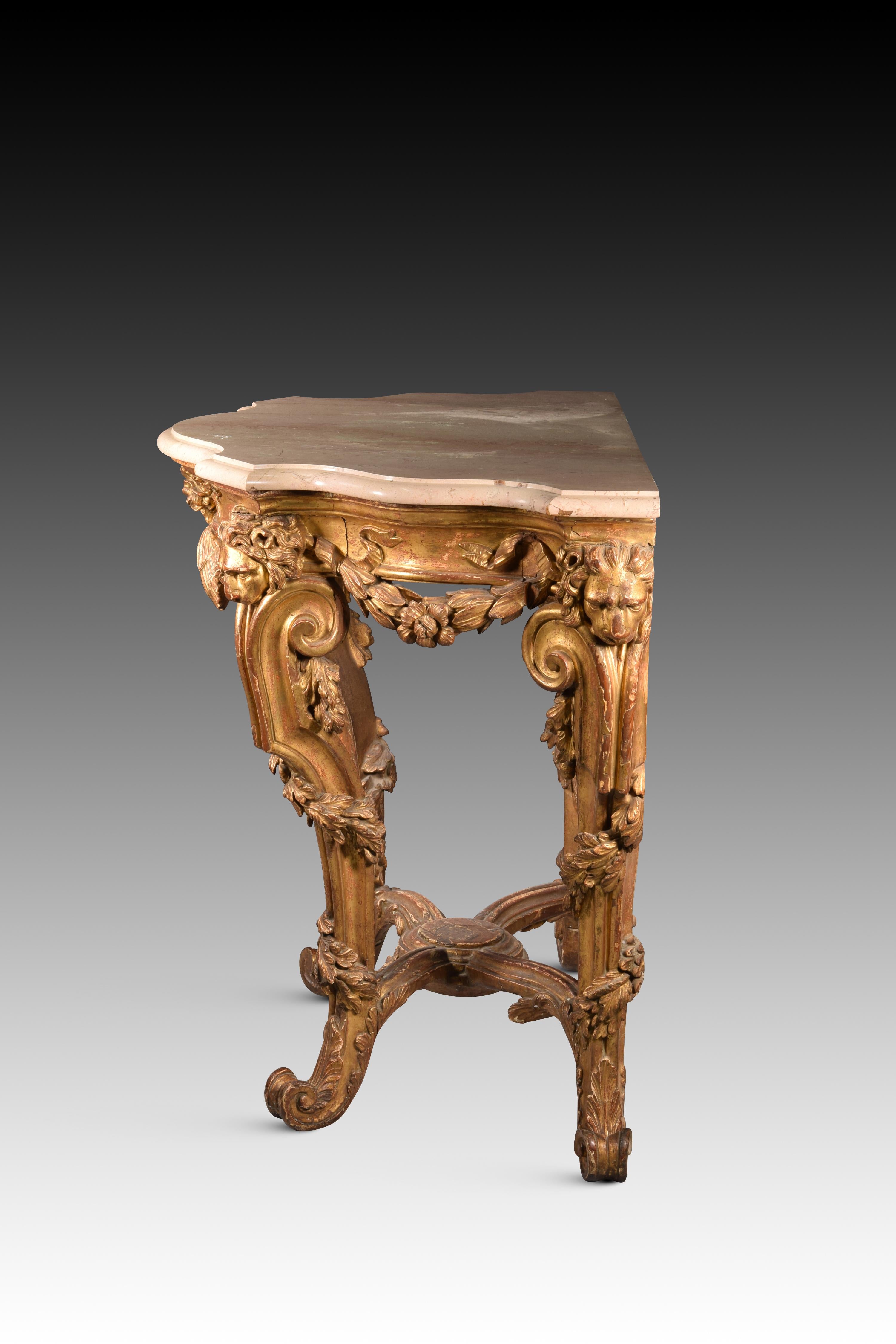 Console table with lion heads. Carved and gilded wood, marble top. Possibly Italian school, 18th century. 
A console table with four legs joined by a jamb that ends in a central piece, made of carved and gilded wood, designed to stand against a wall