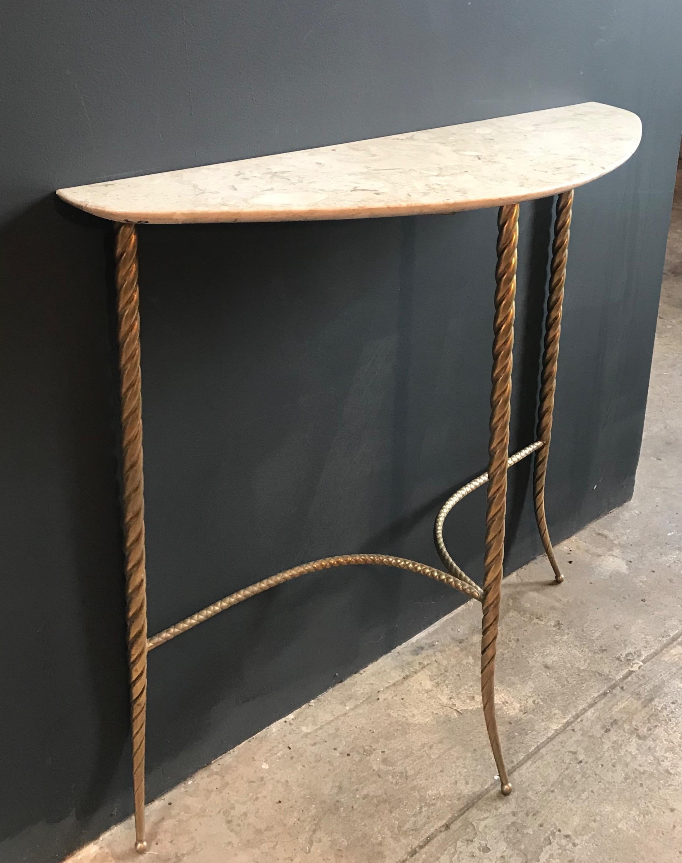 This elegant and tiny console table stands on three legs in full brass and a shaped cream marble top.
Italy, 1940s.
 