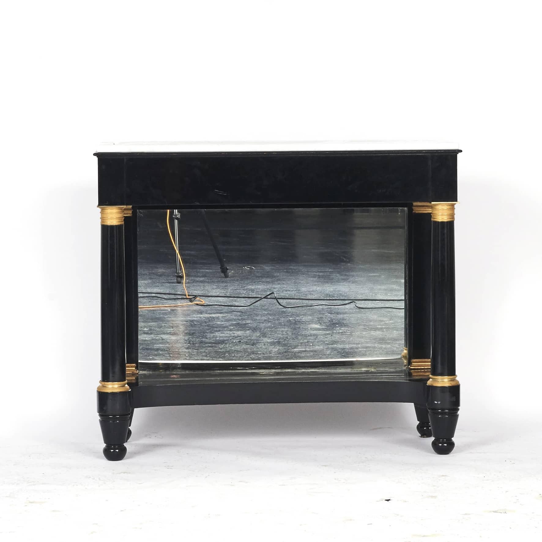 Console table Charles X style.
Black polished mahogany, plate with white marble. Front with columns and gilded bronze capitals.
Rear-mounted mirror in black frame with gilded bronze capitals.
France c.1880.
 