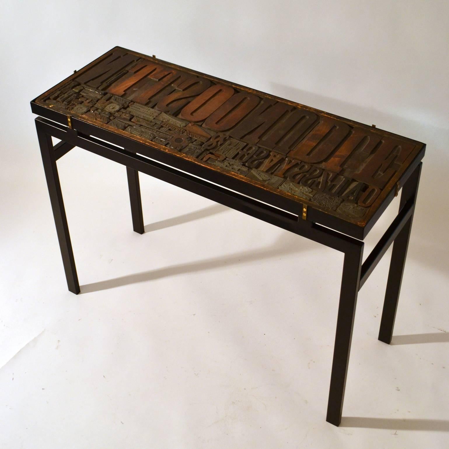 Contemporary Console with Relief Top of Printing Blocks and Glass op on Black Metal Frame For Sale