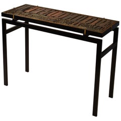 Console with Relief Top of Printing Blocks and Glass op on Black Metal Frame