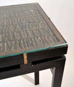 Console with Relief Top of Printing Letters and Glass Top on Black Metal Frame
