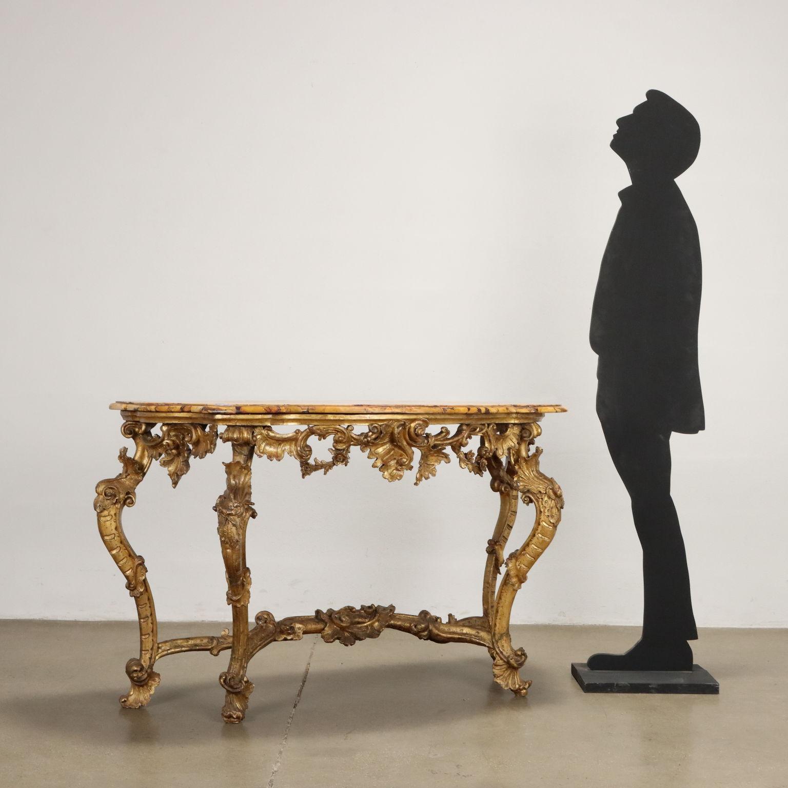 Baroque carved and gilt wood console table with Giallo di Siena marble top, mid-18th-century Florence. Supported by four wavy legs joined together by central crossbeam, the console table is decorated with curly carvings, 