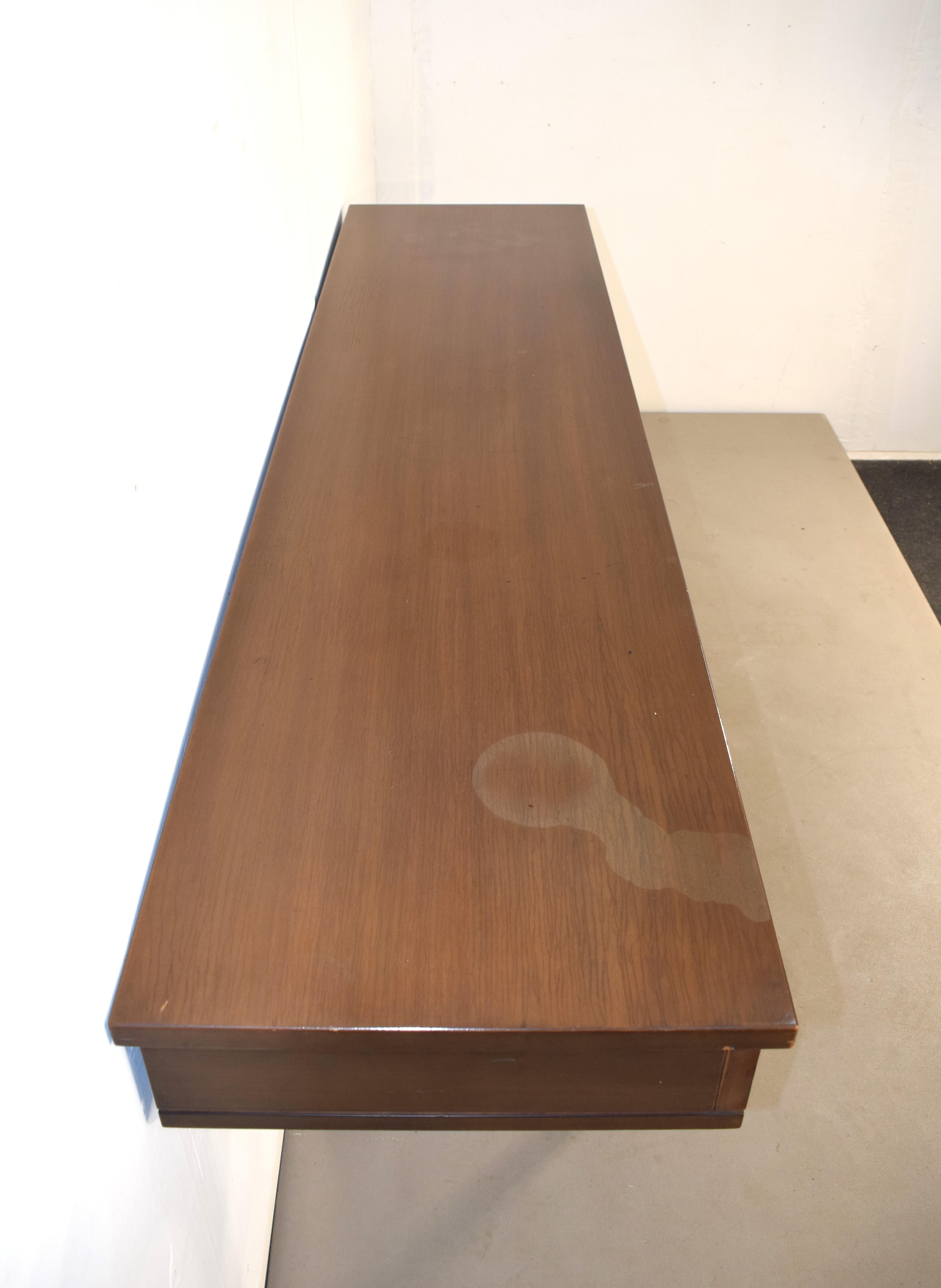 Grande e particolare consolle degli anni 70 di produzione Cantieri Carugati, azienda per cui disegnò anche il noto architetto Gianfranco Frattini.
Realizzata interamente in legno, presenta una struttura solida e resistente, con il tempo, causa