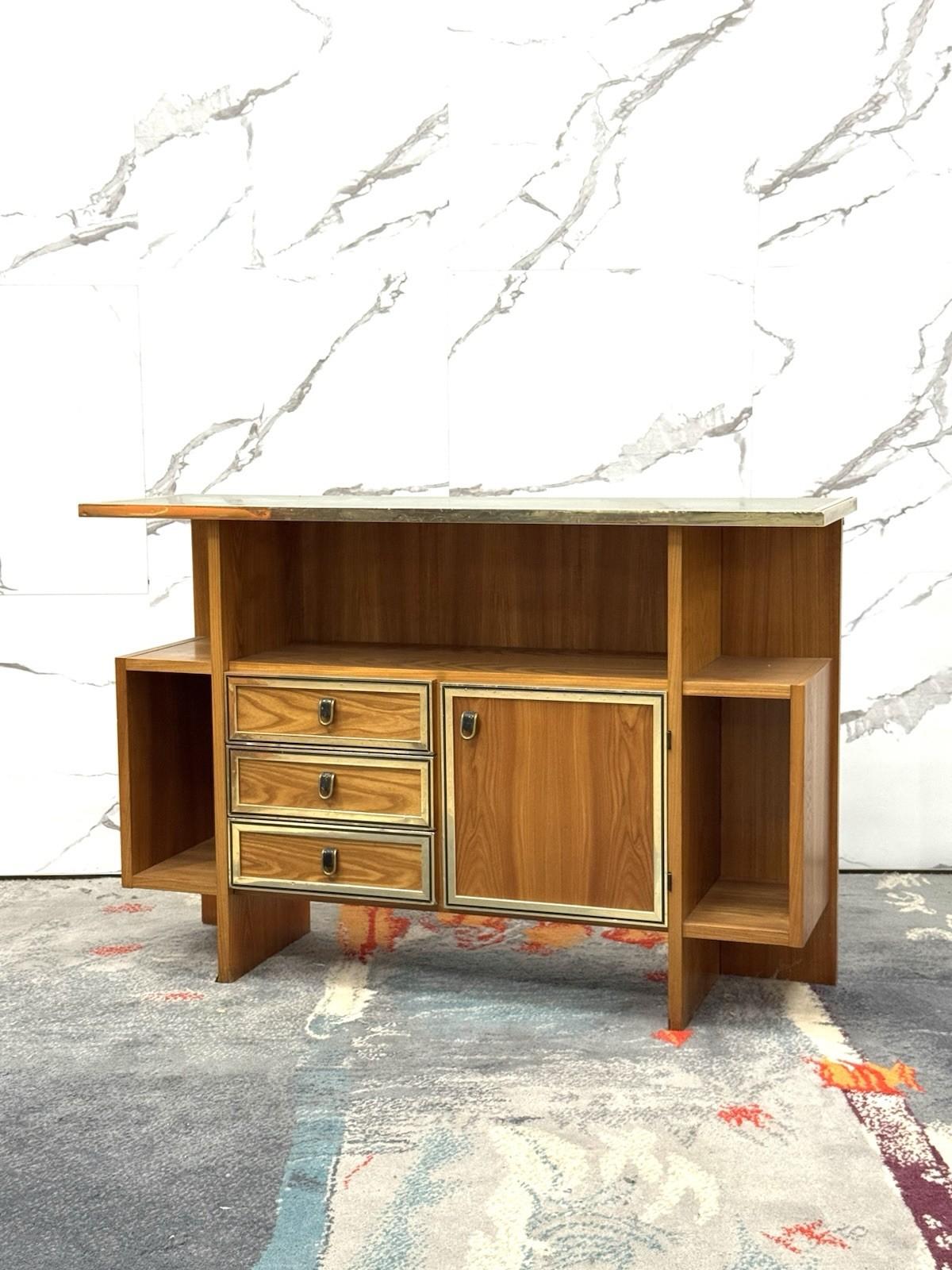 Console Design Scandinavo 1960’s Modernariato.

Struttura interamente in legno, maniglie in ottone, dettagli e profilo in metallo dorato, piano della console in vetro specchiato.

L’articolo si presenta in buone condizioni conservative, sono