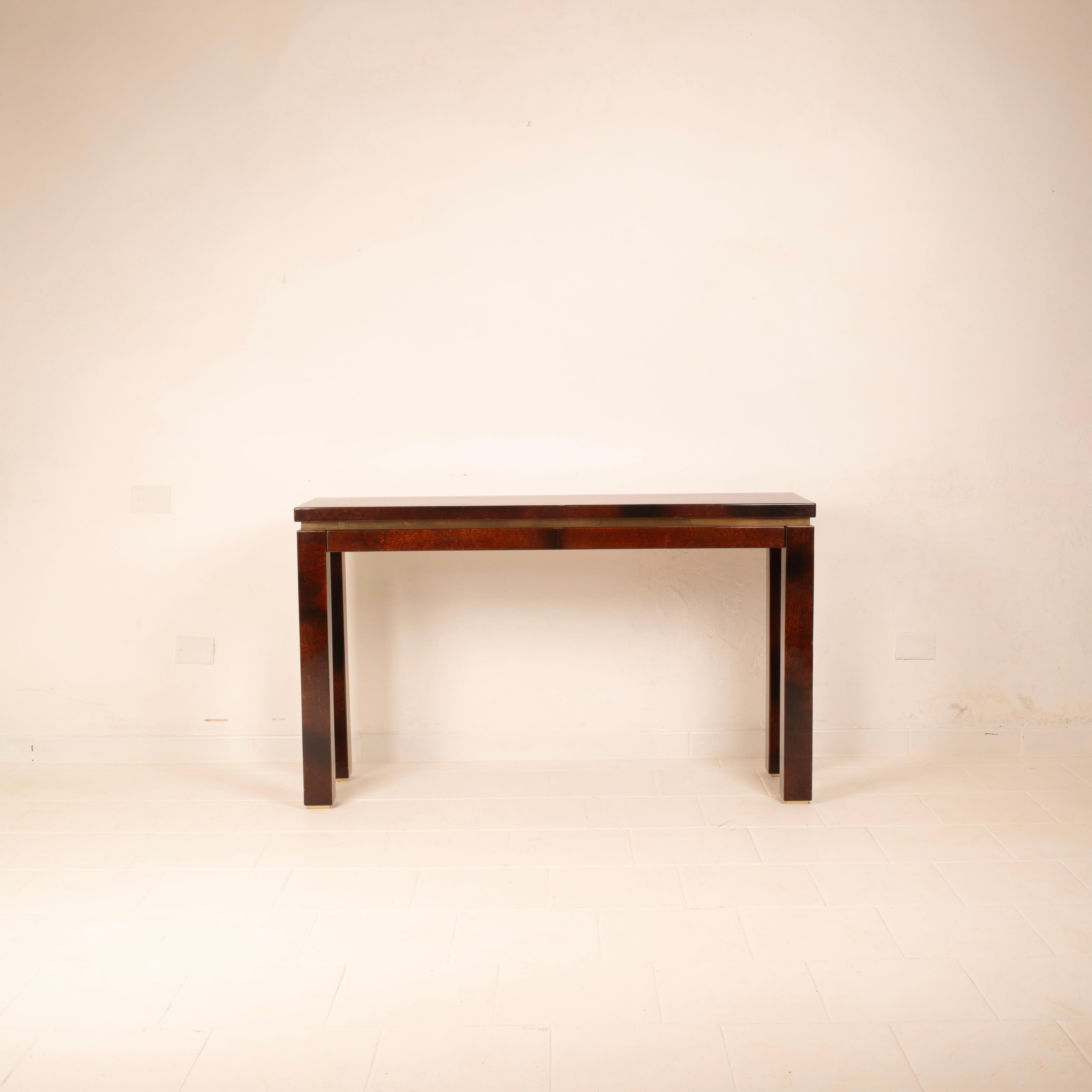 Elegante consola totalmente revestida de pergamino color tabaco, diseñada y fabricada por Aldo Tura en Milán durante la década de 1960.

Su silueta minimalista, definida por líneas limpias y proporciones equilibradas, se enriquece con detalles de