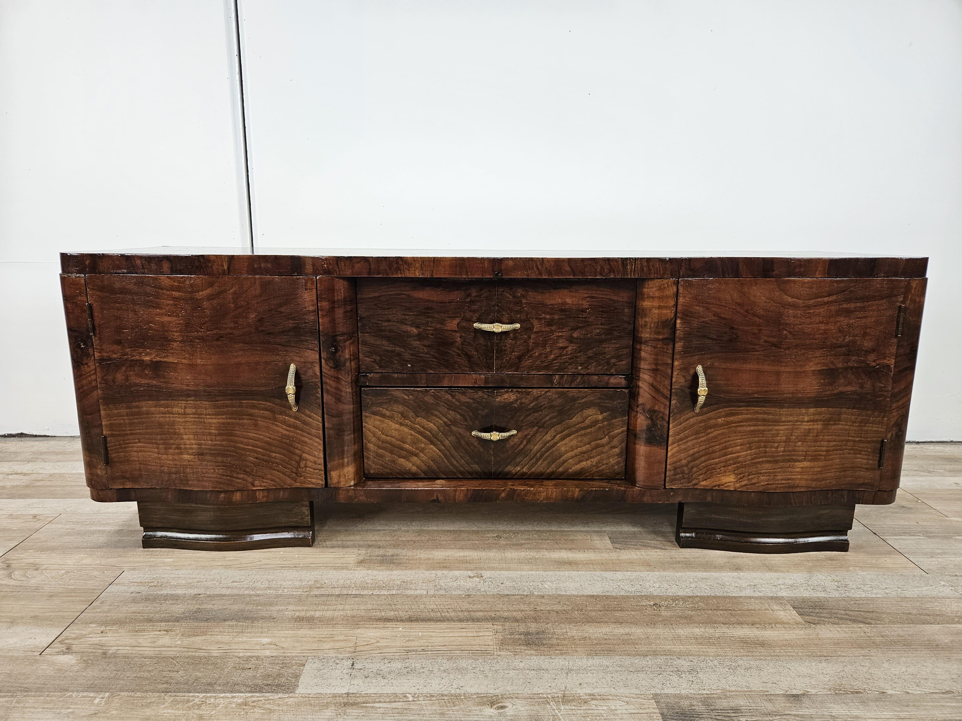 Fine and elegant Art Deco entryway or bedroom cabinet in mahogany burl with two doors and two large, sturdy central drawers.

The console table is decorated with brass handles and is very distinctive for its soft, restrained lines thanks in part to
