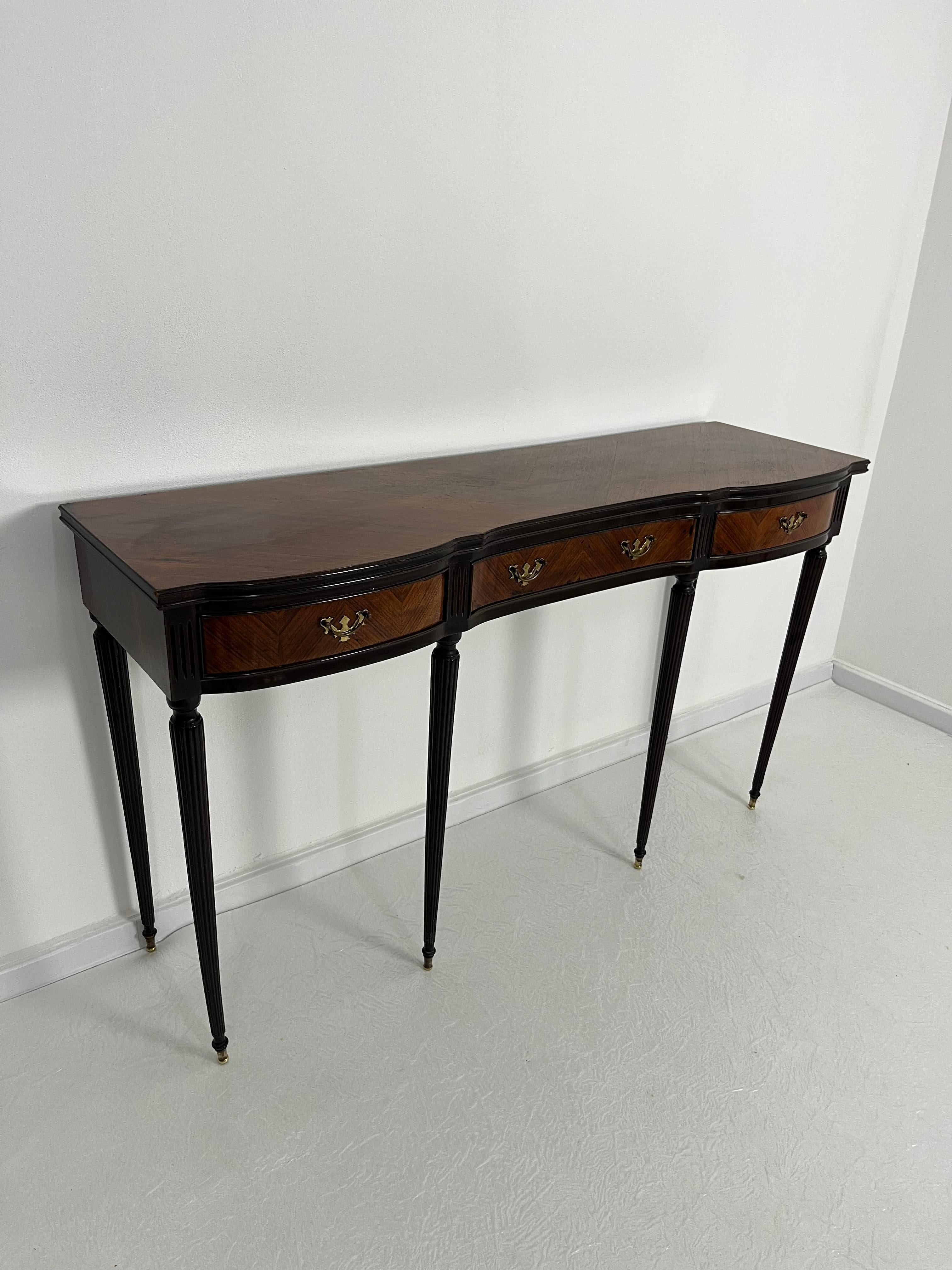 Consolle italiana Mid-Century con piedini e maniglie in ottone, nello stile di Paolo Buffa, anni '60
Tre cassetti sul frontale.
Legno di noce.
Buone condizioni.
Rinvenuta in un appartamento di unricco commerciante della mia città, Palermo.