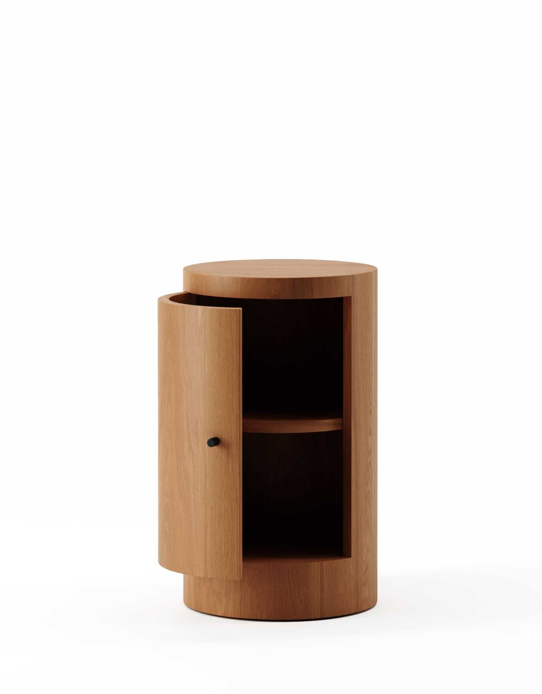 Der von Designer Yaniv Chen entworfene Nachttisch Constant strahlt einen Hauch von raffiniertem Luxus aus und zelebriert die inhärente Pracht von Iroko-Holz. Dieses bemerkenswerte, aus Westafrika stammende Holz hat einen faszinierenden honigfarbenen