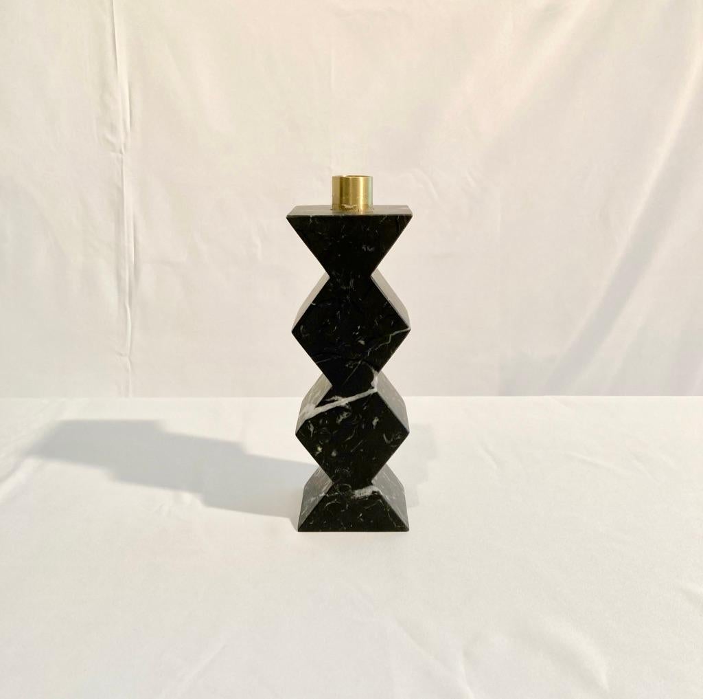 This is a unique set. A prototipe that will not be produced again.
Constantin is a simple but charming candleholder with a geometric shape with circles and rhombus. The body is in Marquina black marble. The cylinder in natural brass on the top is