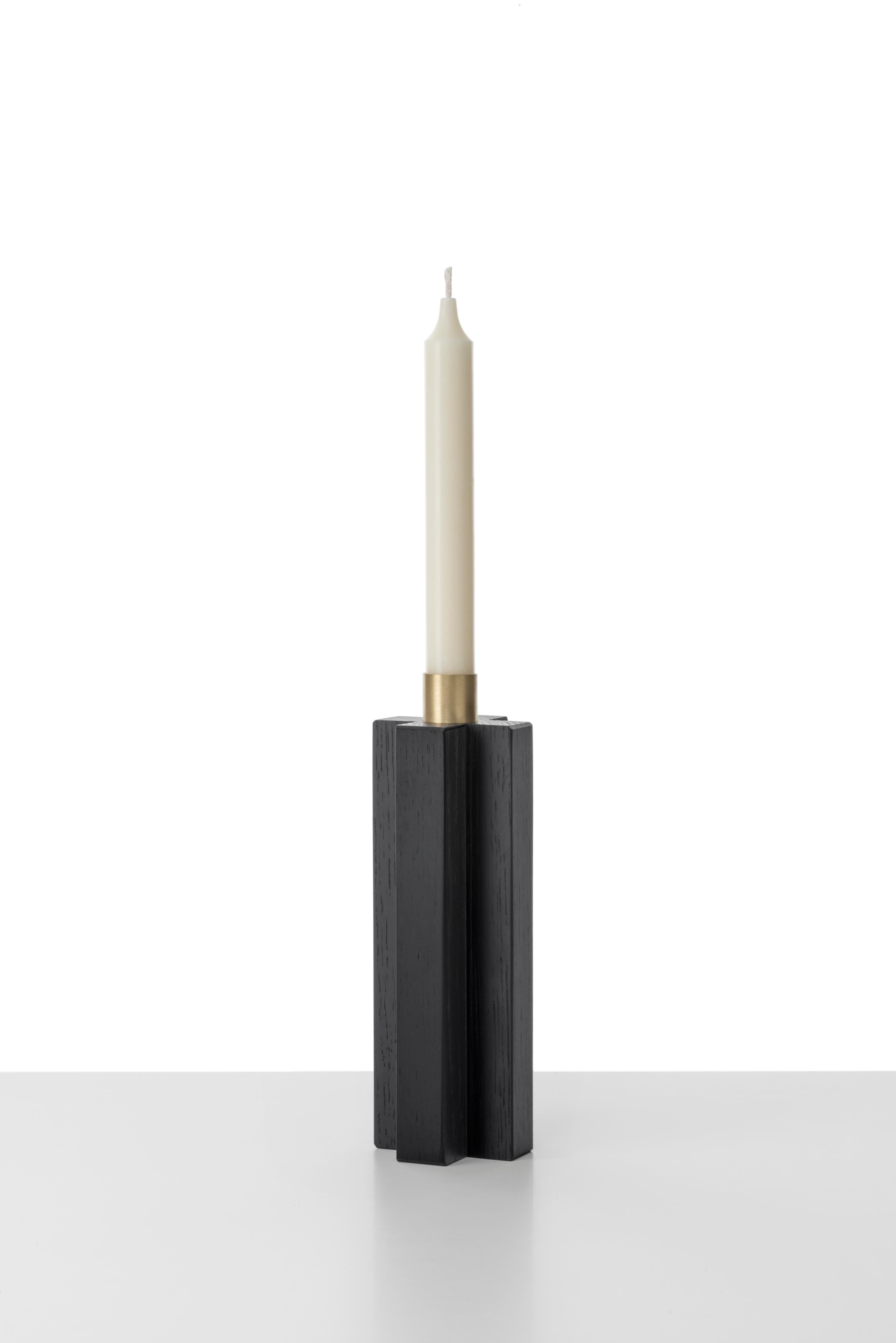 Constantin is a simple but charming candleholder with a geometric shape. The body of Constantin I is in solid oak painted black shaped with a cross, Constantin III in Canaletto walnut shaped with rhombus. The cylinder in natural brass on the top is