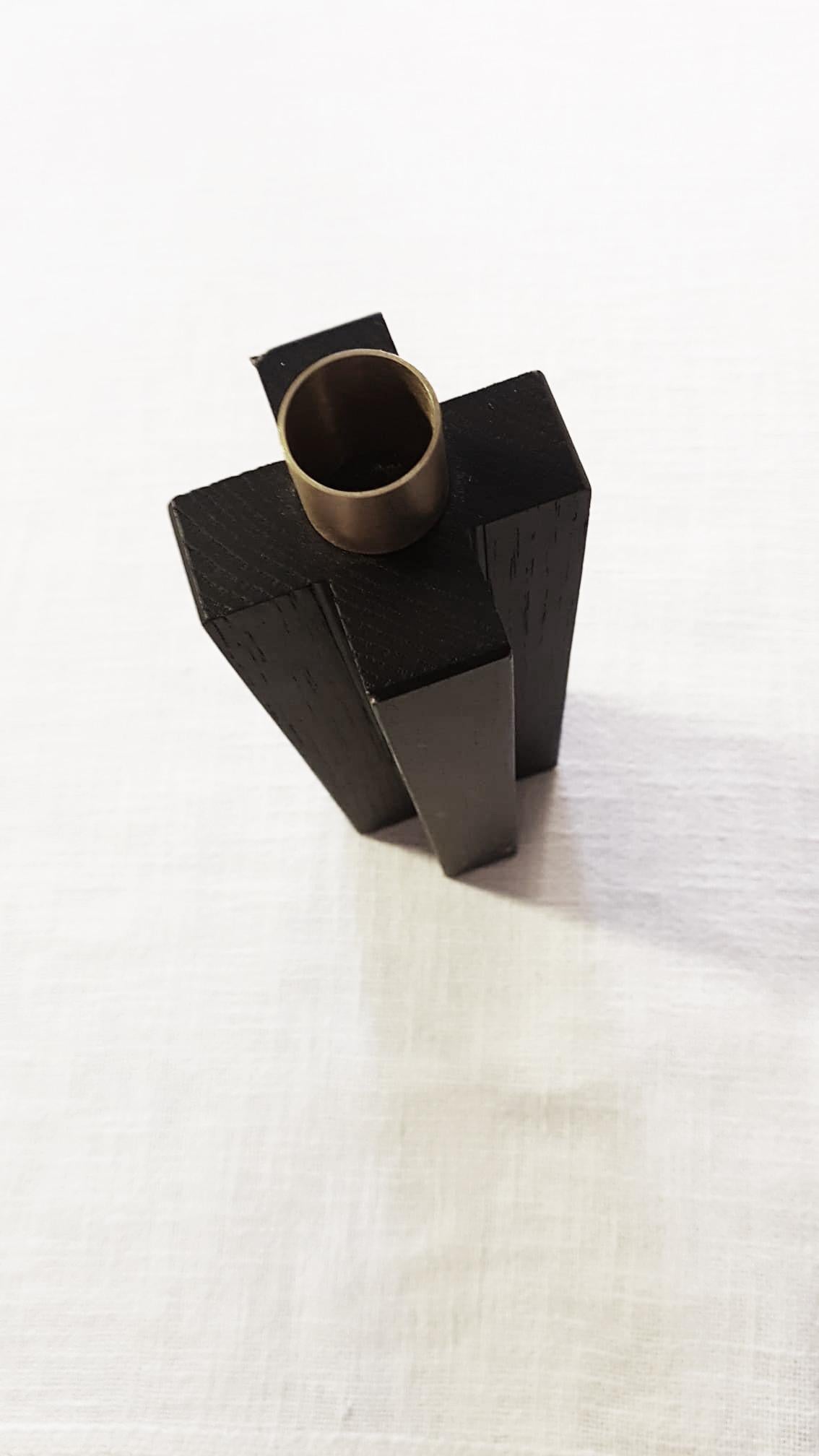 Constantin II is a simple but charming candleholder with a geometric shape with cross. The body is in solid oak wood painted black. The cylinder in natural brass on the top is the place where to put an 18 mm candle.
In the same collection 3