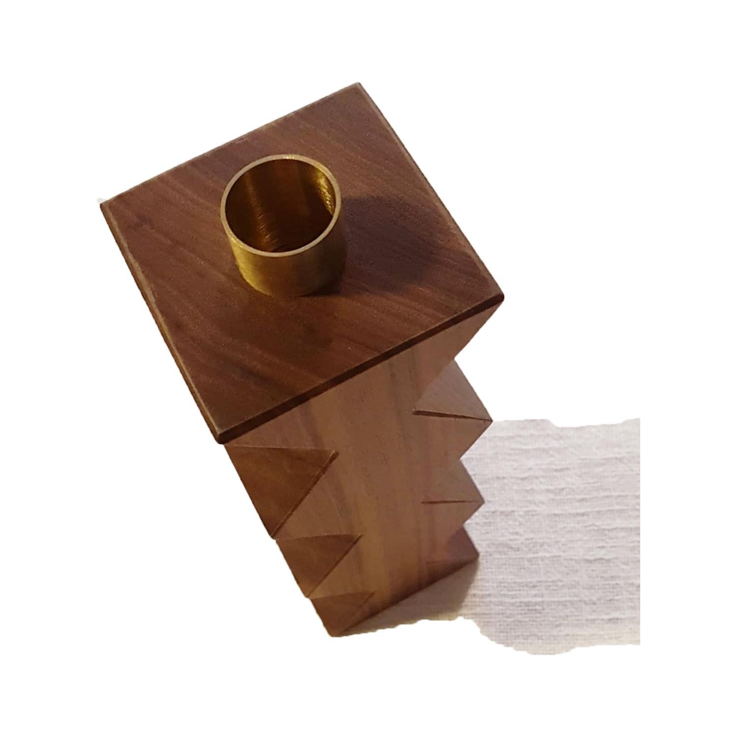 Constantin III is a simple but charming candleholder with a geometric shape with rhombus. The body is in solid Canaletto walnut with natural finishing, emphasizing the wooden veins. The cylinder in natural brass on the top is the place where to put