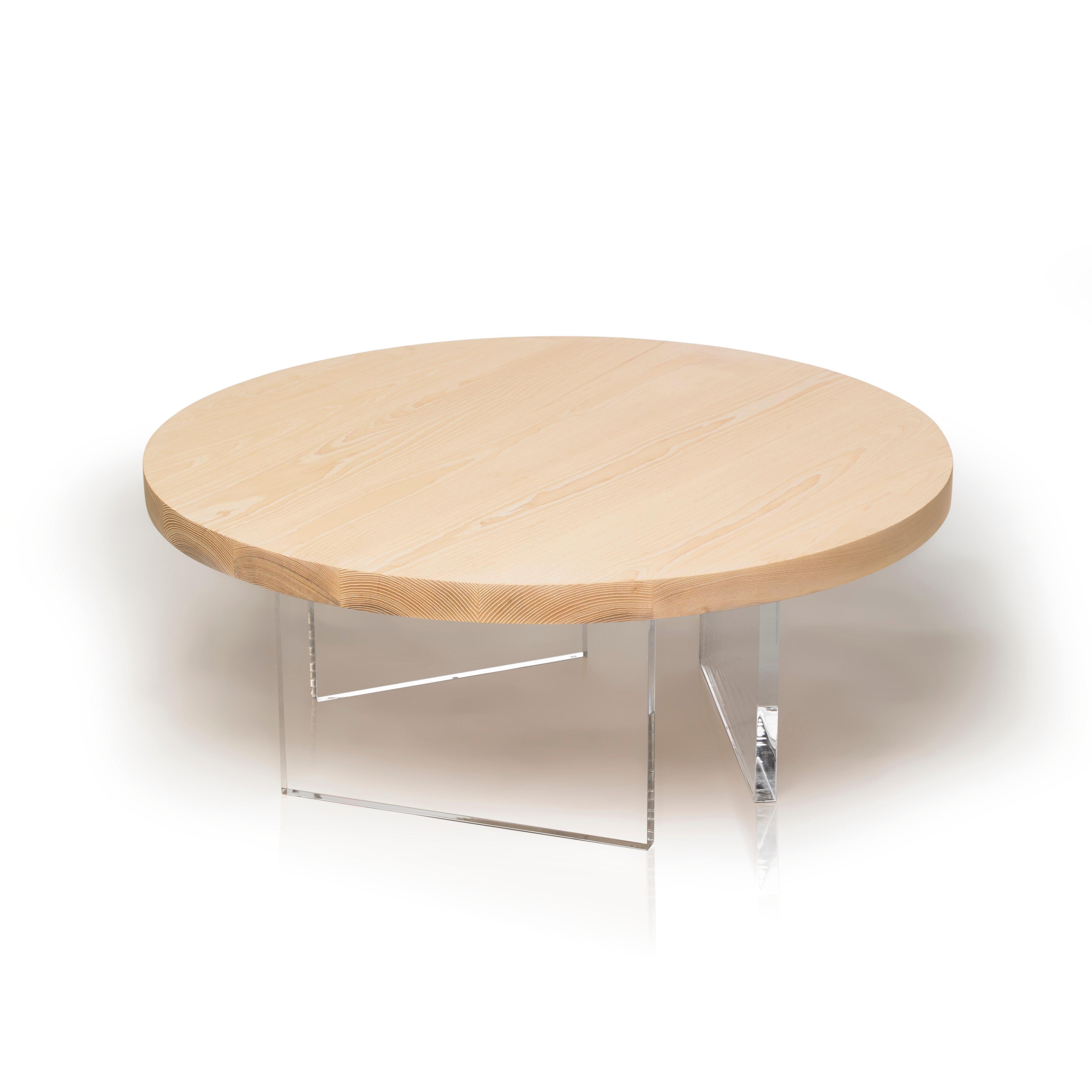 The refined Constantinople Round coffee table in whitened ash solid wood provides a contemporary and clean-lined feel to its space. The tabletop sits on three asymmetrical acrylic one-inch thick legs that allow light to pass through for an airy,