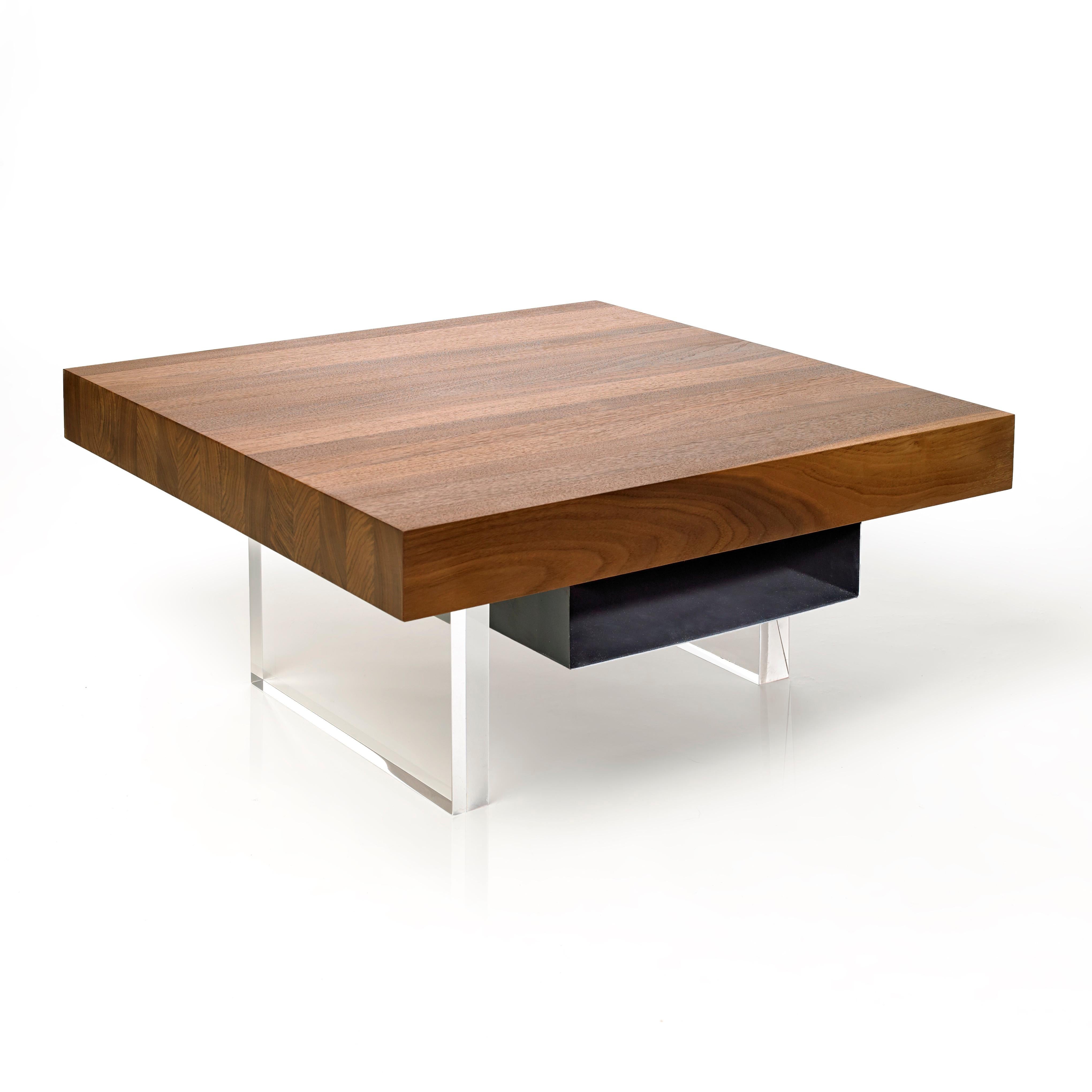 The refined Constantinople Square coffee table in solid Black Walnut provides a rich and dramatic look to its space. The tabletop sits on two one-and-a-half-inch acrylic legs slightly offset that allow light to pass through for a floating effect to