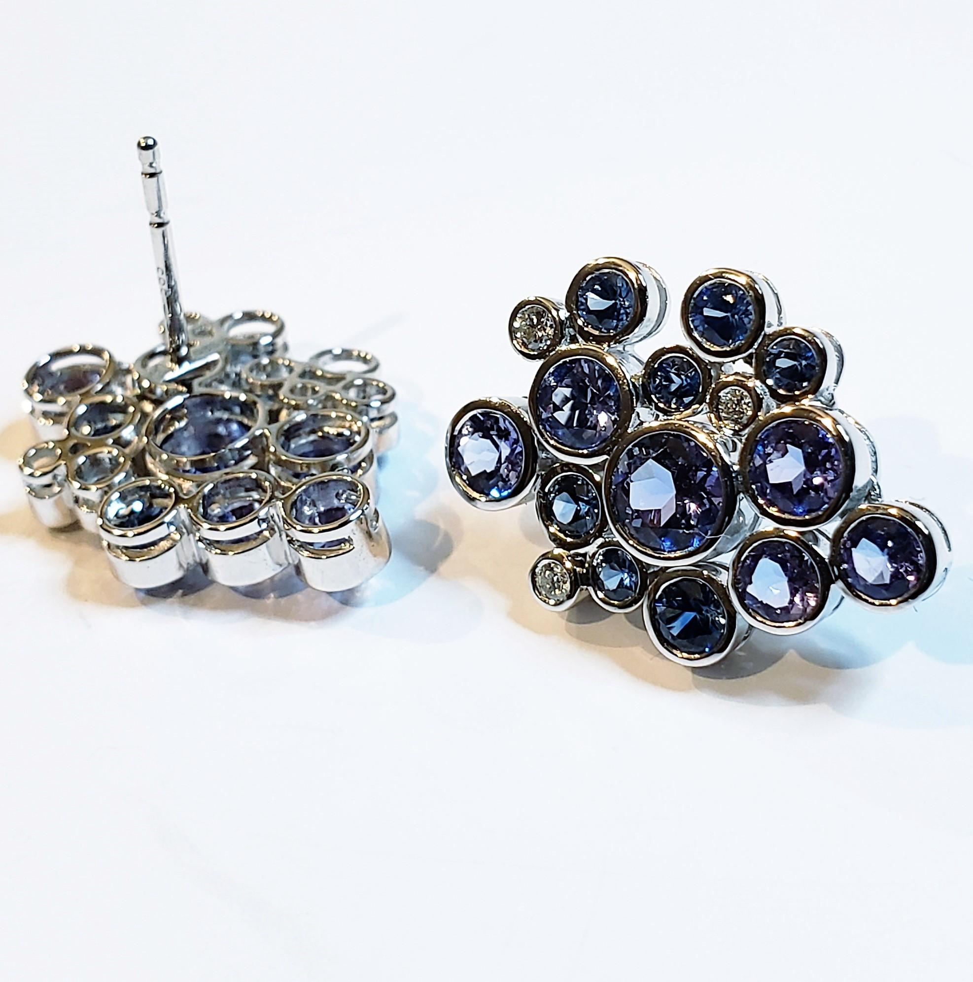 These are multi- stone post earrings. Each stone is bezel set. There are twelve round, sapphires, tanzanites plus diamonds. The gemstones come together to form the sparkling Constellation Cluster post earrings in 14k white gold. Special order in