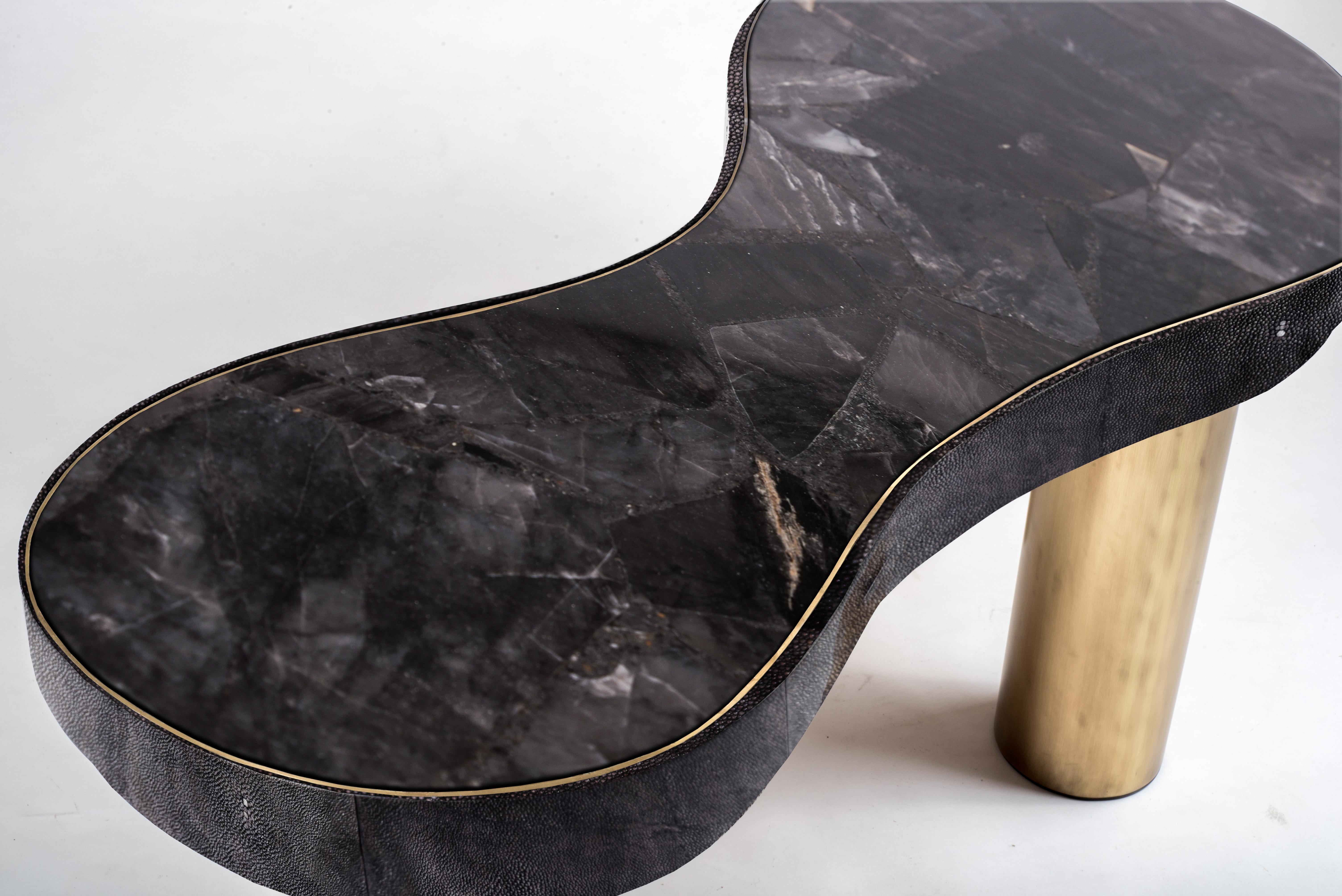 The constellation coffee table is whimsical and elegant with its galactic inspired shaped. This piece can also double as a bench. The top is inlaid in a beautiful Black Quartz semi-precious stone that has incredible tonalities in it and details. The