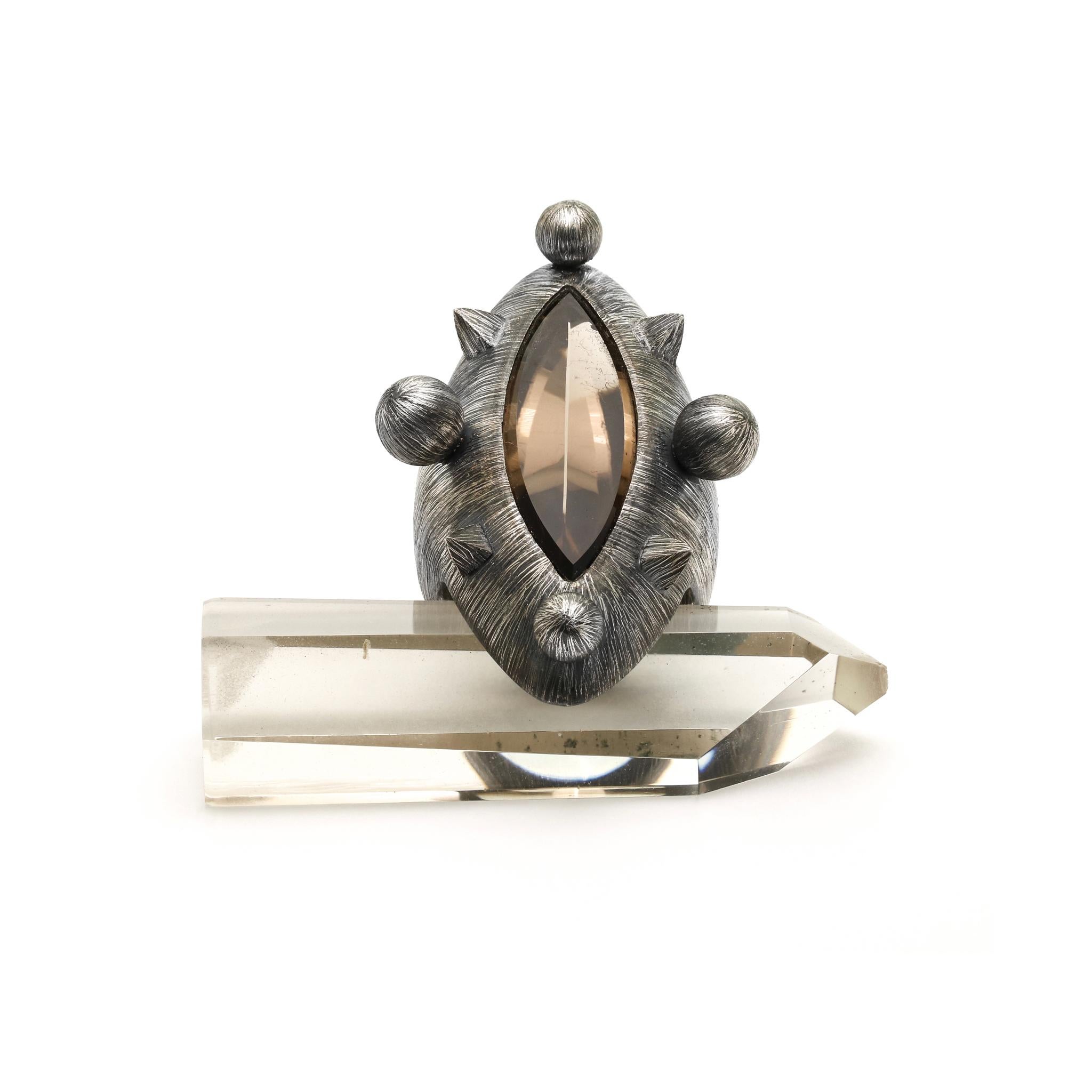 This ring, adorned by pyramids and spheres represent a constellation of stars orbiting the refracted light emanating from the cut quartz at the center.
925 Sterling Silver Etched & Oxidized
1,5 x 3cm Smoky Quartz 
the ring size is 1,18