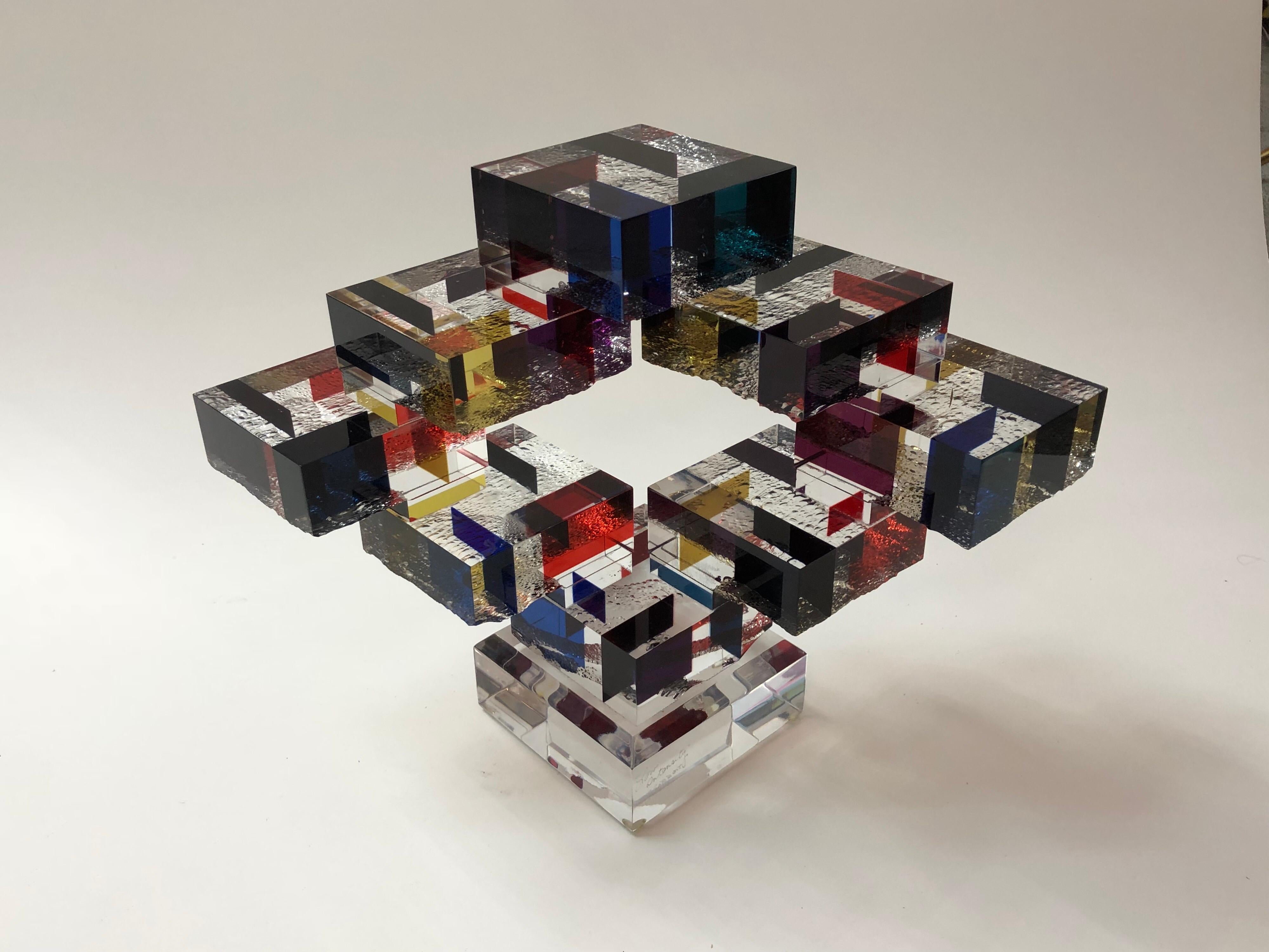 This is a very interesting and well crafted table sculpture. The Lucite cubes have multiple colors and texture on one side, they are arranged in an outward and upward design. Signed and dated. Name of sculpture is 