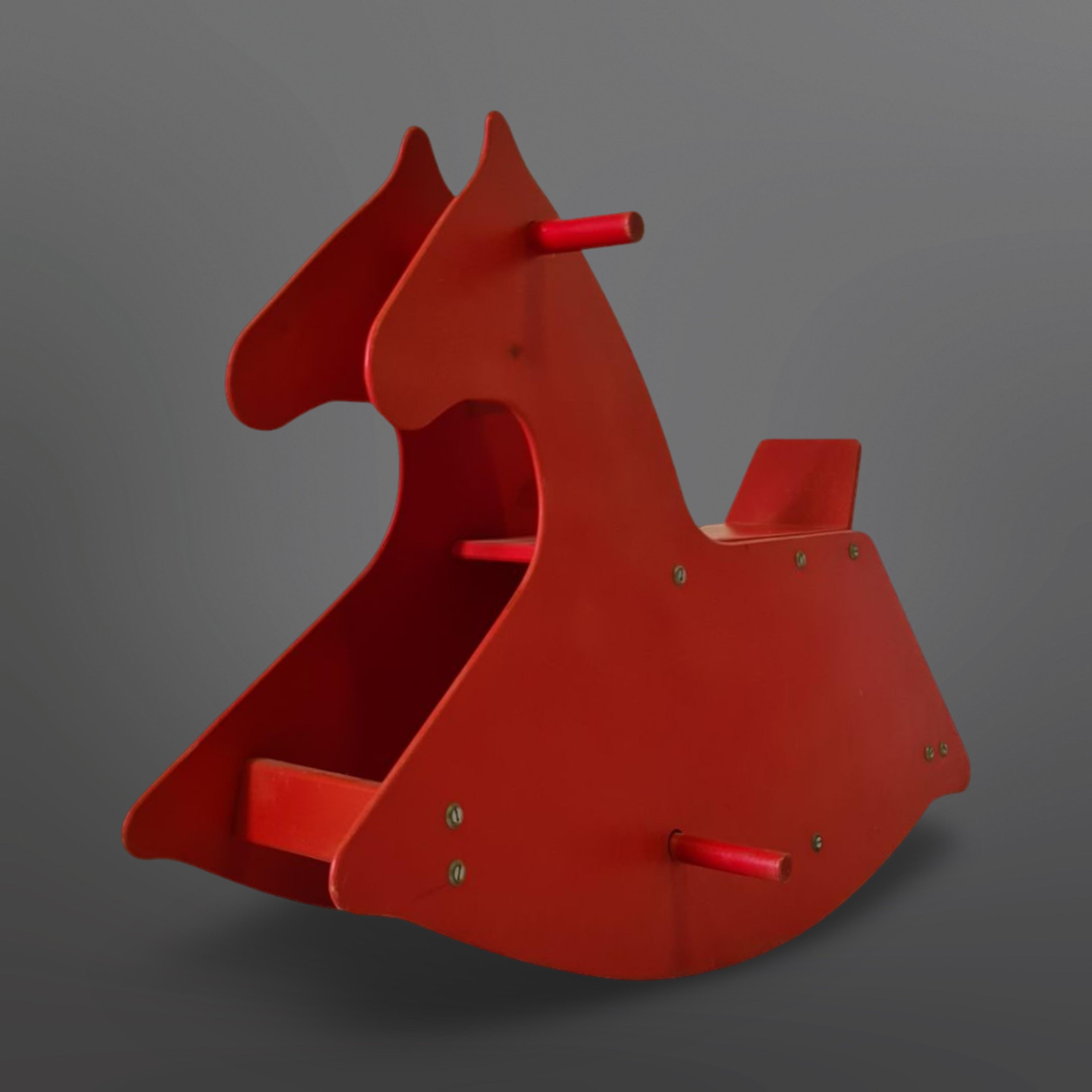 Minimal Bauhaus design rocking horse. It is made from sheets of plywood. Simple yet ingenious construction making it a sturdy toy. I was made during the 1960s in Switzerland. 
The plywood has the original red paint. The horse is in very good