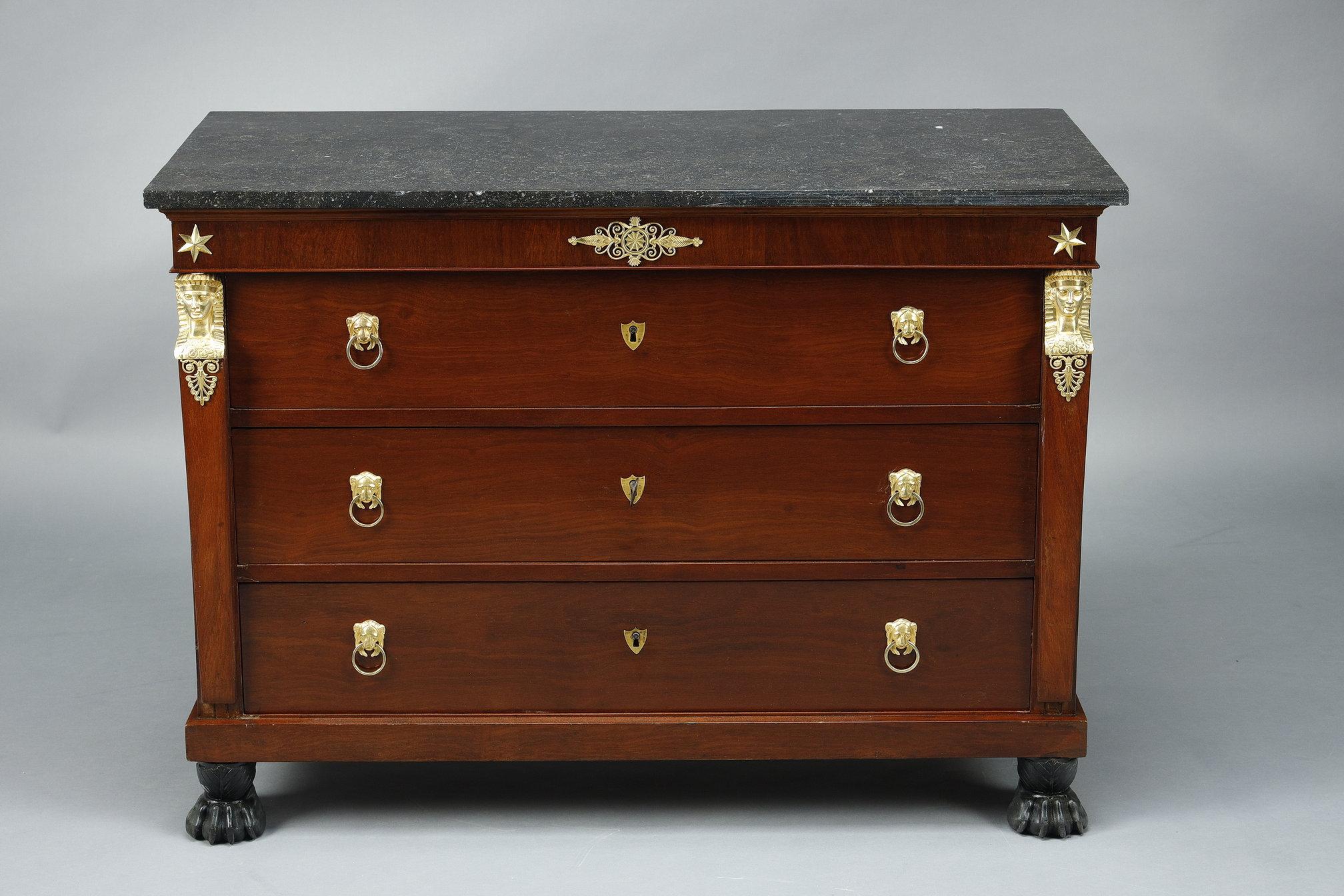 A mahogany and mahogany veneer bedroom set from the Consulat retour d'Egypte period (circa: 1795) comprising :

- A mahogany and mahogany veneer chest of drawers with columns veneered with Egyptian heads in gilt bronze. It opens with 3 drawers in