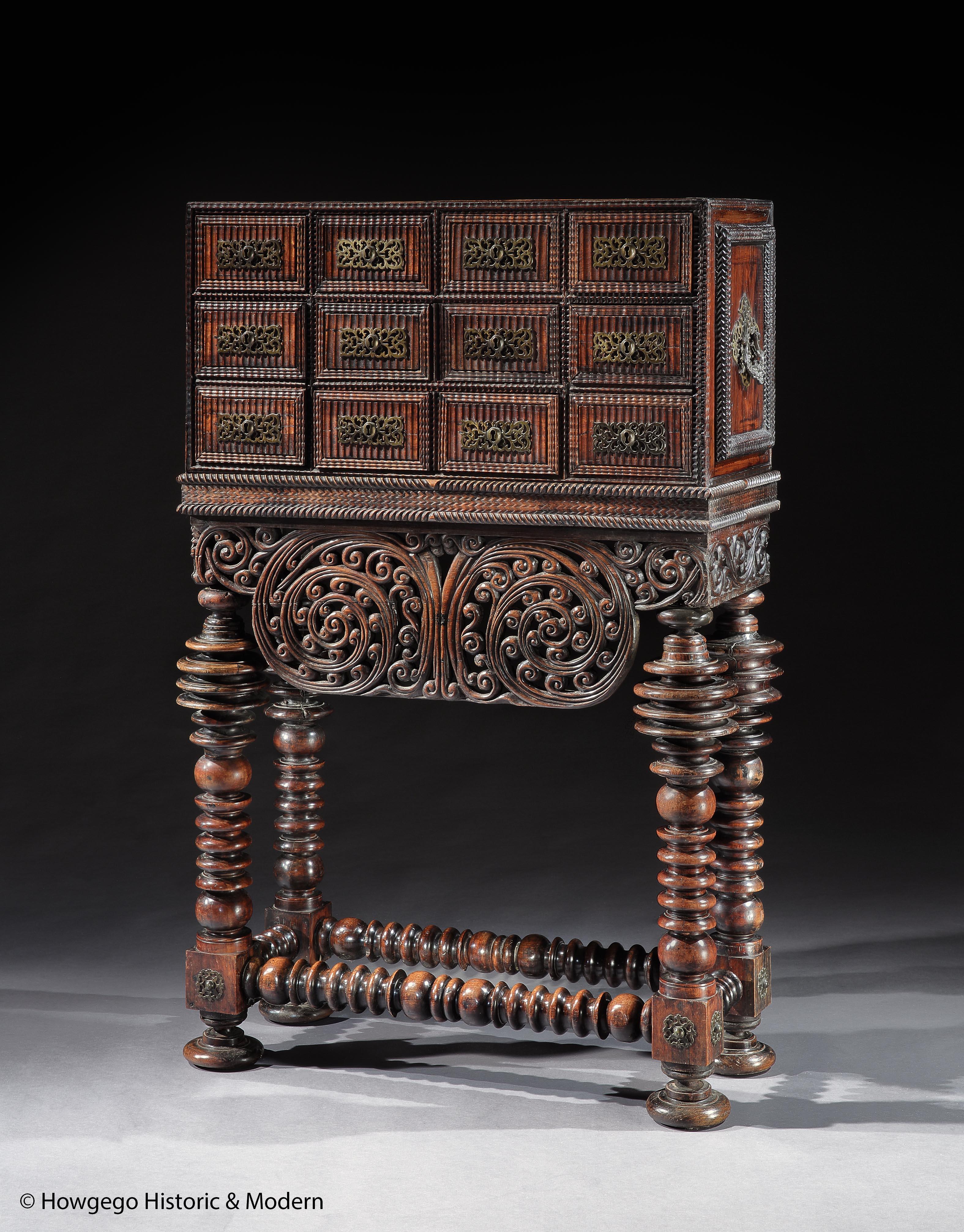 A STRIKING, MUSEUM QUALITY, BAROQUE, PORTUGUESE BRAZILIAN, ROSEWOOD & VINHÁTICO CONTADOR OR CABINET ON STAND WITH BRASS MOUNTS
- Masterpiece of carved ornament, with tremidos or fluted, ripple-effect drawer fronts, deep mouldings exhibiting a