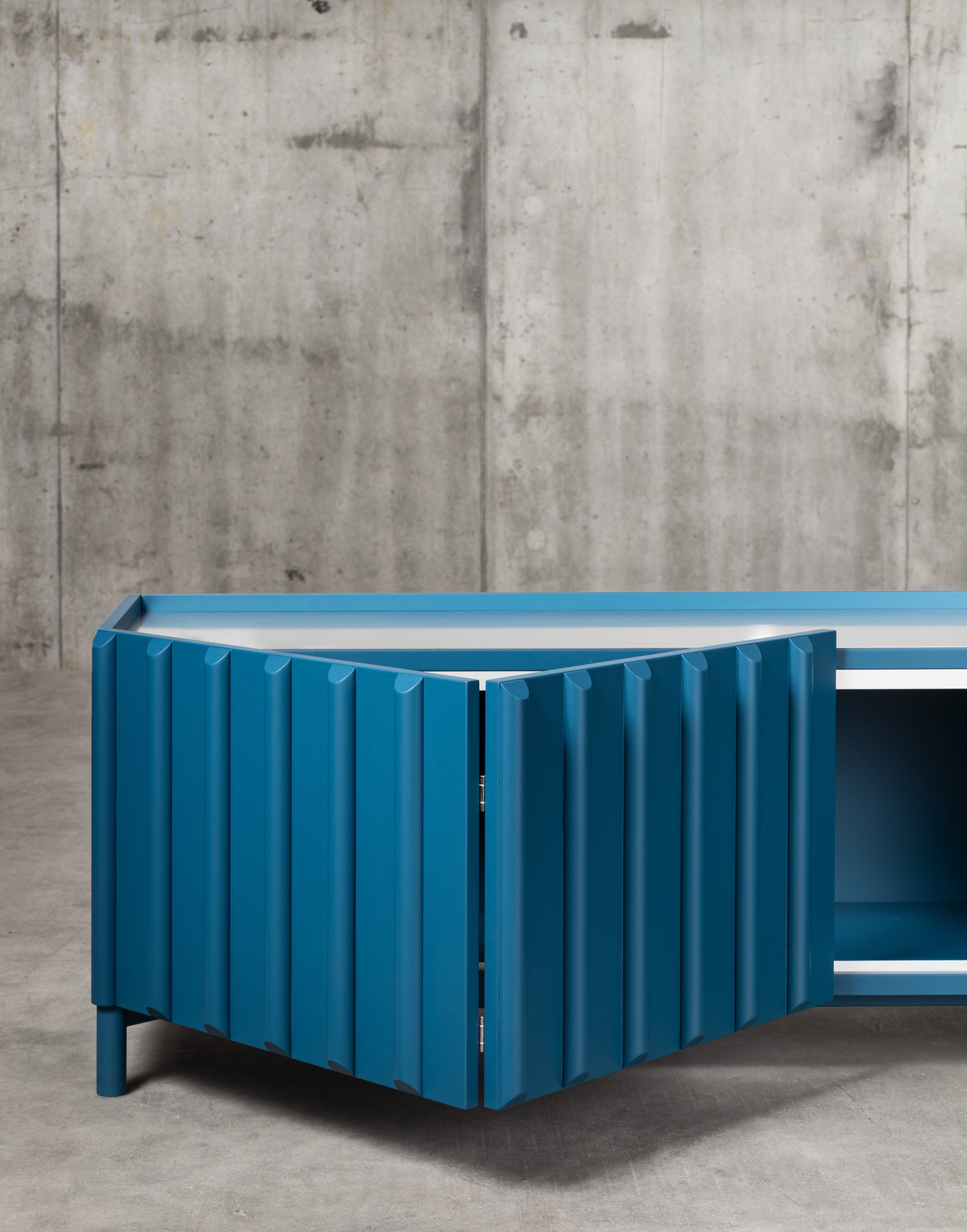 Sideboard with structure in wooden essence or lacquered in the colours listed in Campionario, with base in the same colours and porcelain stoneware top. Zinc-coated base and top is also available on request.

