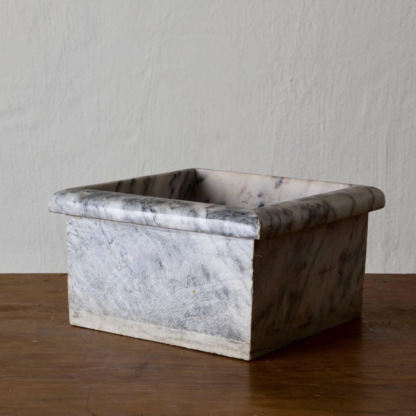 A large square container made in French during the 20th century. Made in gray and white marble.
 