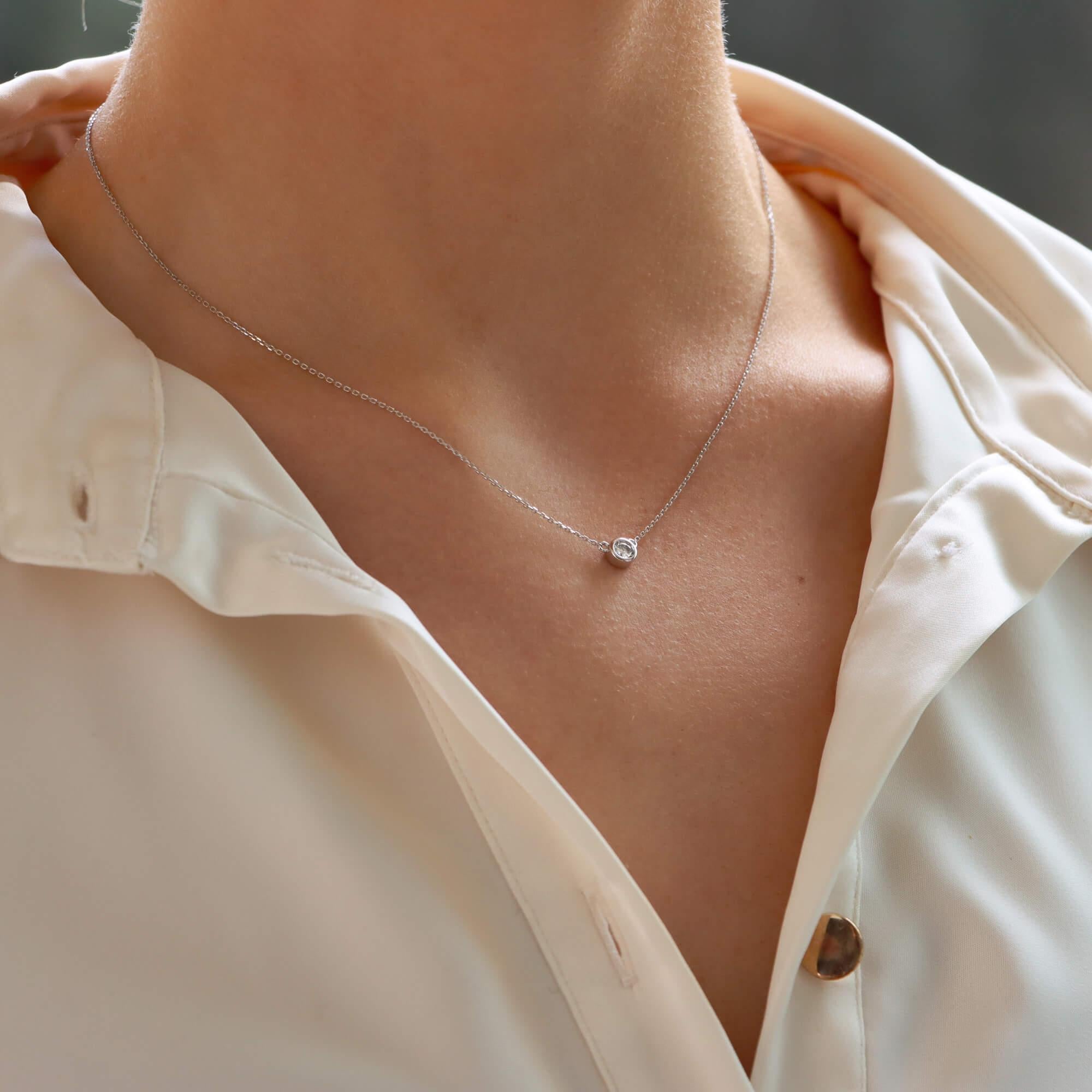 A beautiful contemporary single solitaire diamond pendant set in 14k white gold.

The pendant is solely set with a sparkly round brilliant cut diamond that is rub over set in a shiny white gold setting. The pendant hangs from a 16-inch fine white
