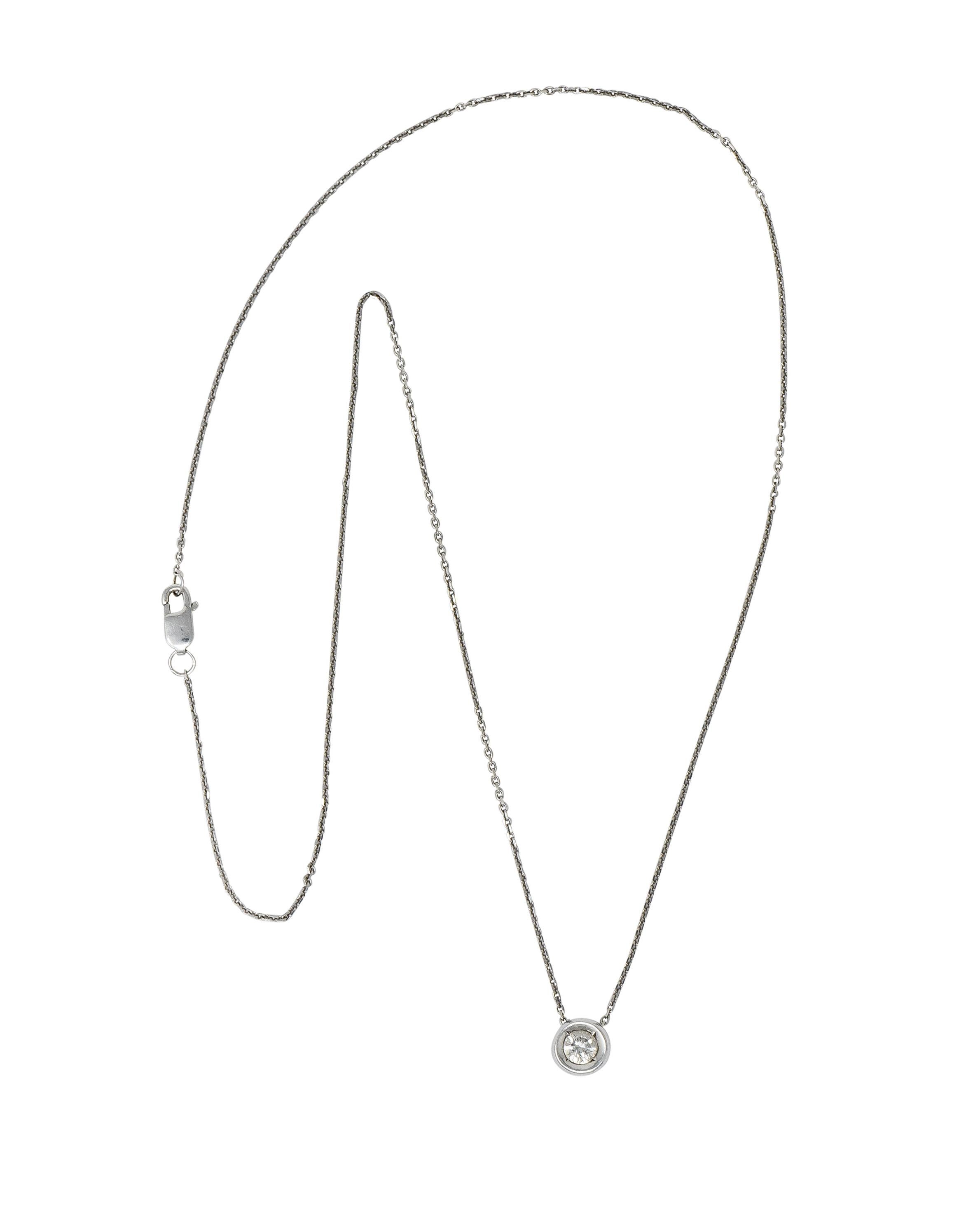 Centering a round brilliant cut diamond weighing approximately 0.25 carat, I/J color with SI clarity

Bead set in a puffed and polished gold surround

Threaded on a white gold cable chain necklace completed by a lobster clasp

With maker's mark and