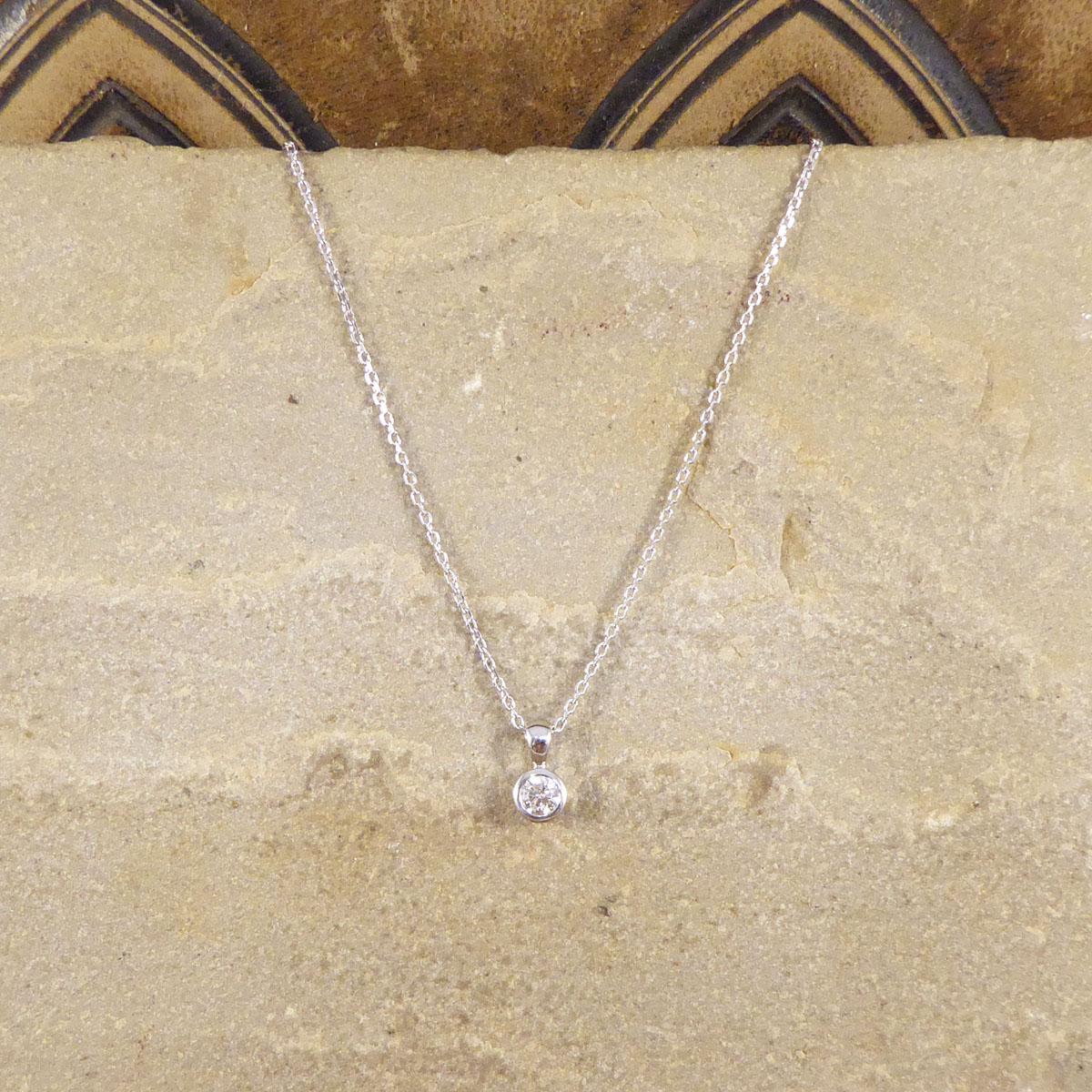 Hanging on a Contemporary 9ct White Gold Chain, sits a beautiful 0.25ct Diamond pendant. So elegant and dainty the 0.25ct Diamond is a Modern Brilliant Cut and is clean and bright. It is set in a rub over 9ct White Gold setting giving it the