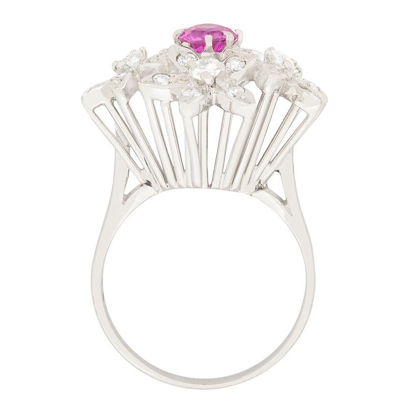 A dreamy pink sapphire is surrounded by four diamond set flowers. The diamonds total to 0.42ct and are estimated to be G in colour and VS in clarity. The 0.35 carat sapphire is a strong pink colour and is round brilliant cut. The ring is made in 18