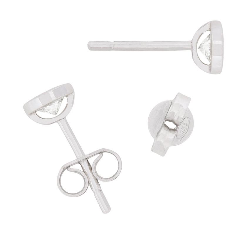 Classic in design and the ideal gift, these simple earrings feature round brilliant diamonds. Each diamond weighs 0.25 carat and is estimated as G in colour and VS2 in clarity. They have been rub over set in 18 carat white gold, and the earrings