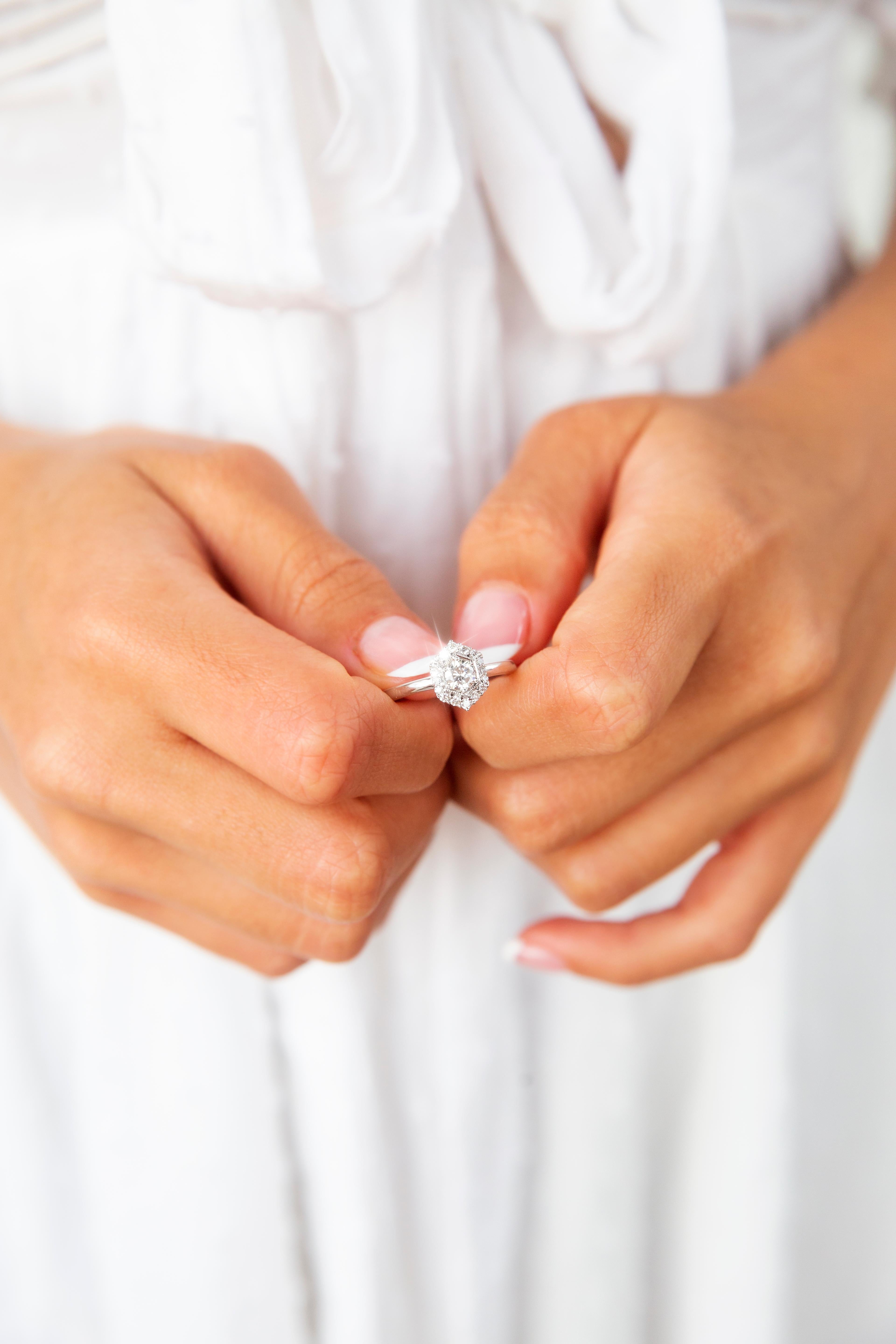 Lovingly crafted in gleaming 18 carat white gold, this gorgeous contemporary halo cluster ring features a captivating 0.33-carat round brilliant cut diamond encompassed by a millegrain border and a hexagonal halo of bead set round brilliant cut