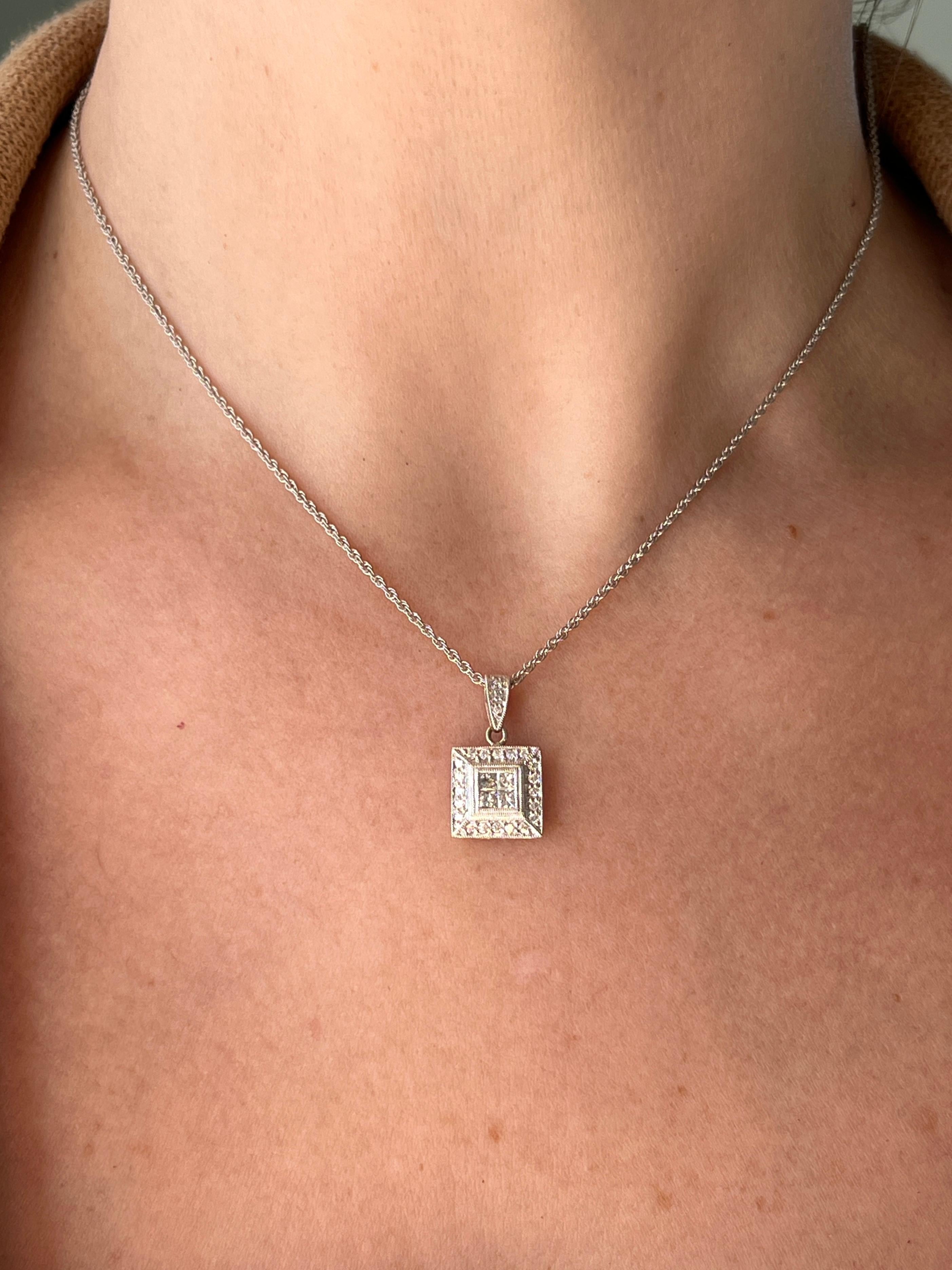 Ce pendentif en or blanc et rose 14 carats, pesant 3,51 grammes, présente un savoir-faire vintage exceptionnel avec quatre diamants de taille princesse et vingt-trois diamants ronds de taille brillant totalisant environ 0,55 carat. Les quatre