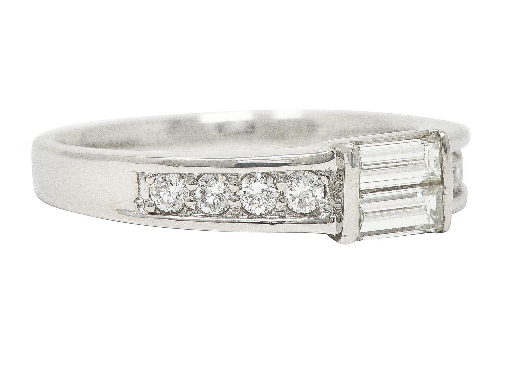 Centering two baguette cut diamonds bar set north to south and weighing 0.24 carat total
Flanked by graduated round brilliant cut diamonds bead set in shoulders 
Weighing approximately 0.32 carat total 
H color with VS1 clarity,