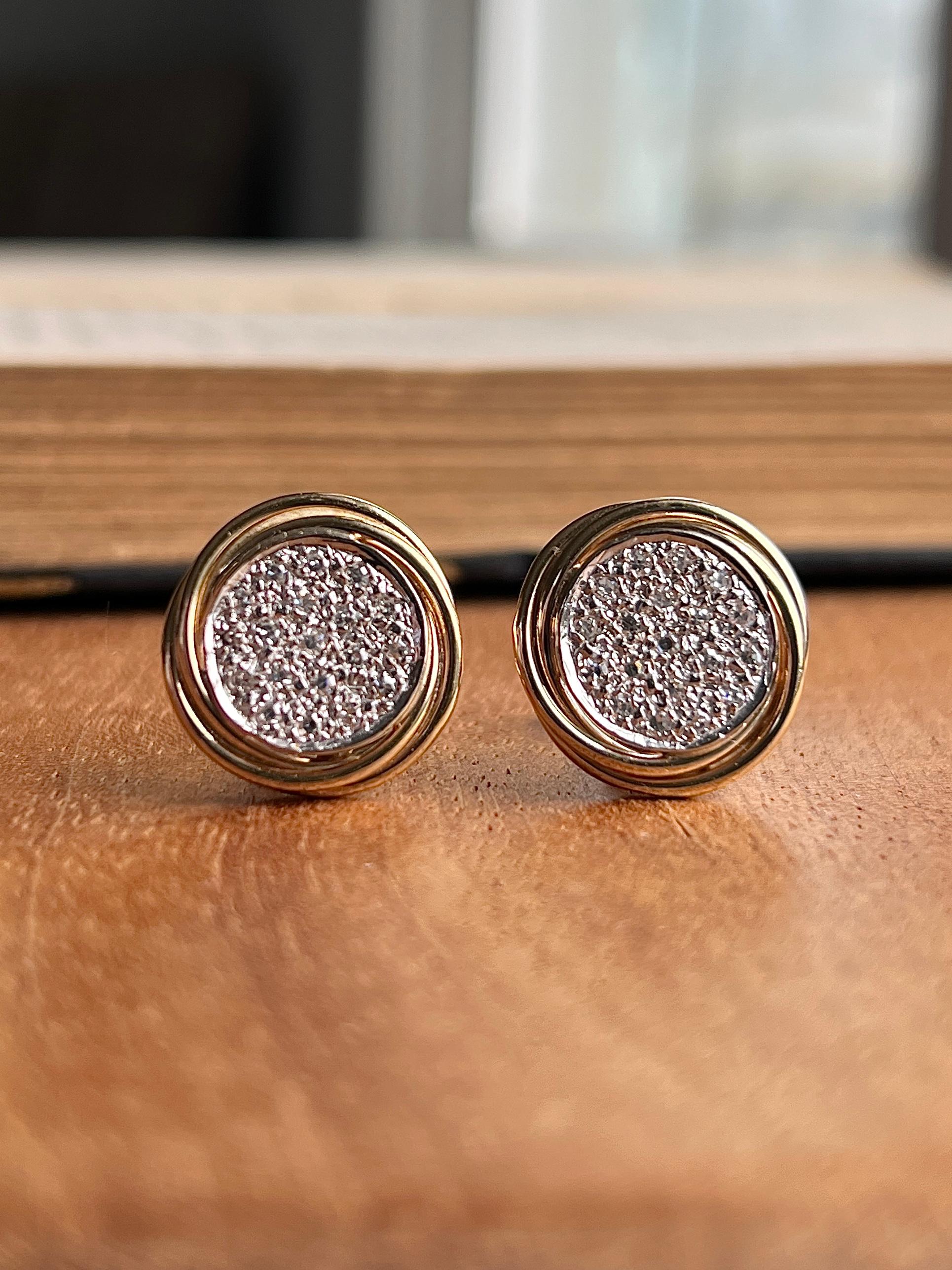 A striking pair of vintage 14 karat yellow and white gold swirl earrings, beautifully crafted in a two-tone design that highlights both texture and brilliance. Each earring is pavé-set with nineteen round single-cut diamonds, totaling approximately
