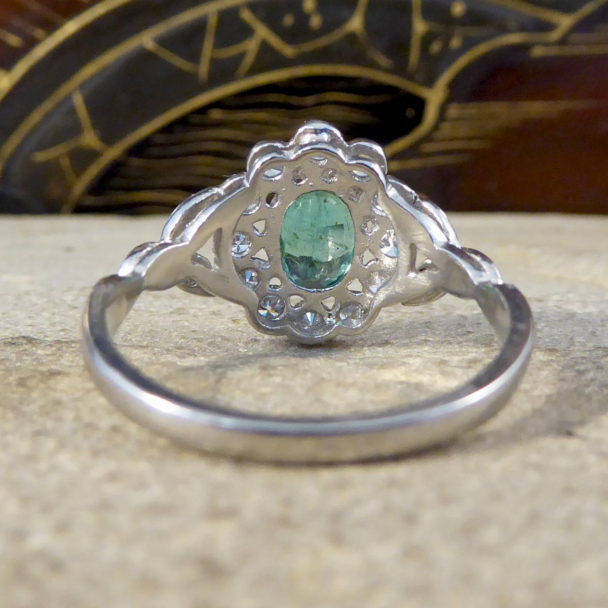 Oval Cut Contemporary 0.75ct Emerald and Diamond Cluster Ring with Shoulders in Platinum