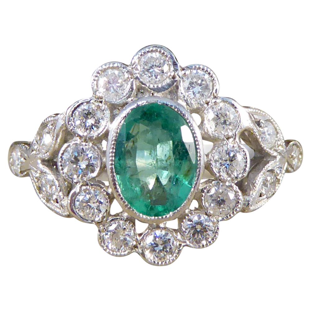Contemporary 0.75ct Emerald and Diamond Cluster Ring with Shoulders in Platinum