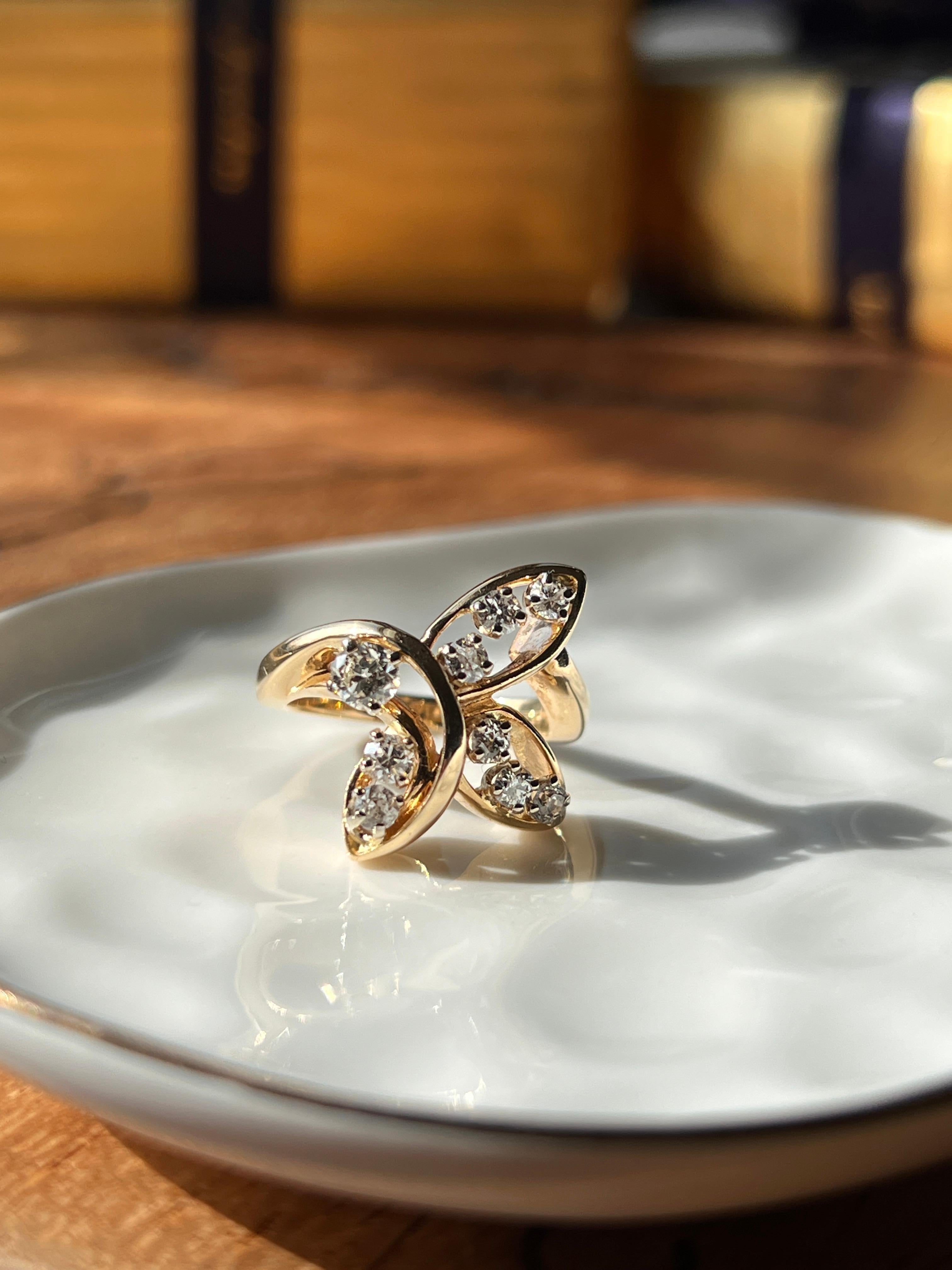 Questo anello contemporaneo in oro giallo 14 carati presenta un grazioso design a forma libera con nove diamanti tondi taglio brillante per un totale di circa 0,76 carati, con colore H-J e purezza SI1-I2. L'incastonatura fluida e traforata evoca la