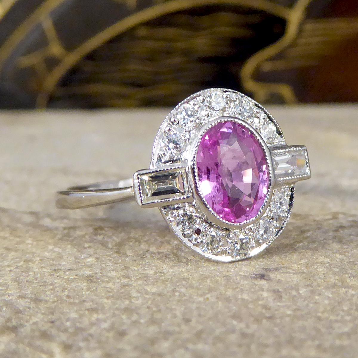 This captivating and pretty pink Sapphire weighs 0.95ct with a surround of Diamonds weighing 0.35ct in total of both modern brilliant cut and baguette cut Diamonds. All the gems are set in a rub over collar setting with a millegrain edge resembling