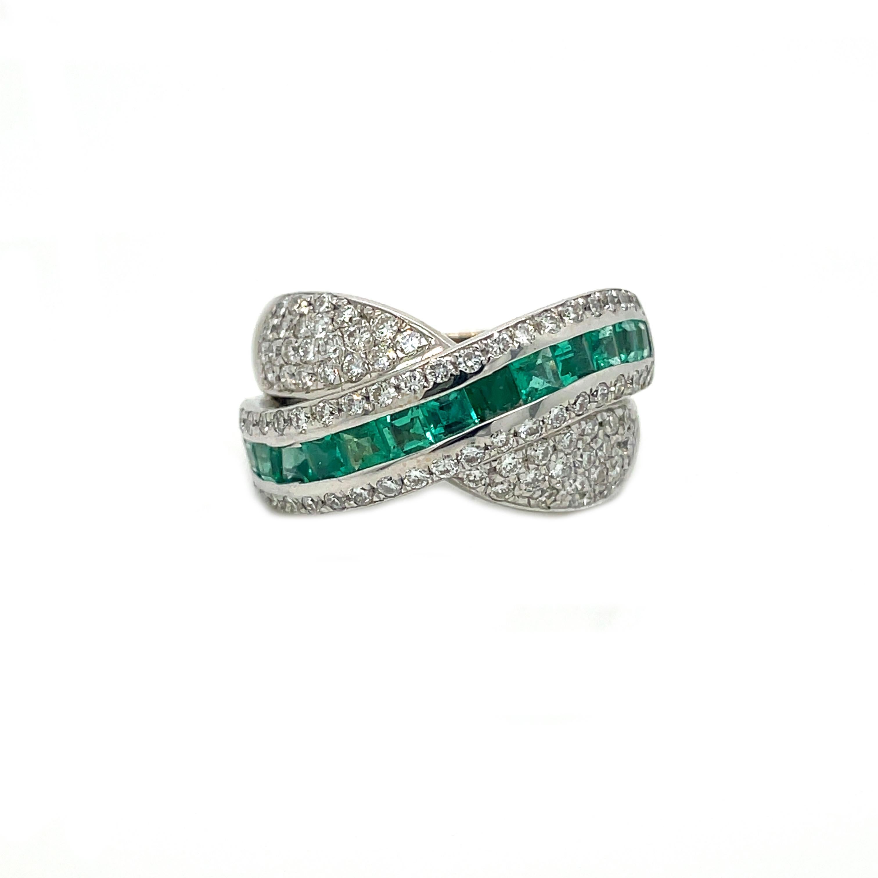This is a breathtaking Contemporary ring that features gorgeous vivid green emeralds and bright white diamonds in a beautiful crossover design. There is no doubt that this ring will be seen from tables away! This is the perfect ring for someone
