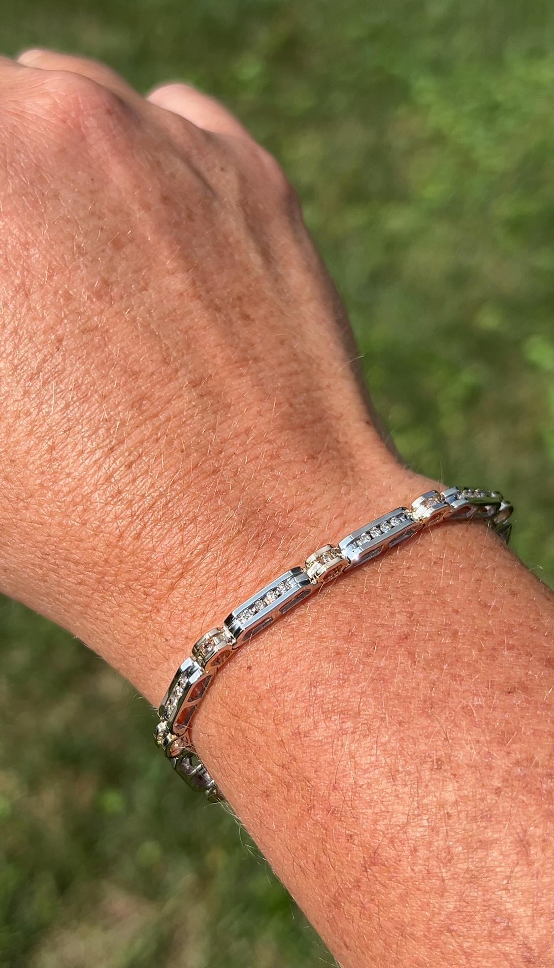 Un bracelet ligne intemporel des années 1990 en or bicolore 14 carats, conçu avec des sections alternées d'or jaune et d'or blanc pour un look polyvalent et élégant. Le bracelet est serti de cinquante diamants ronds de taille brillant totalisant