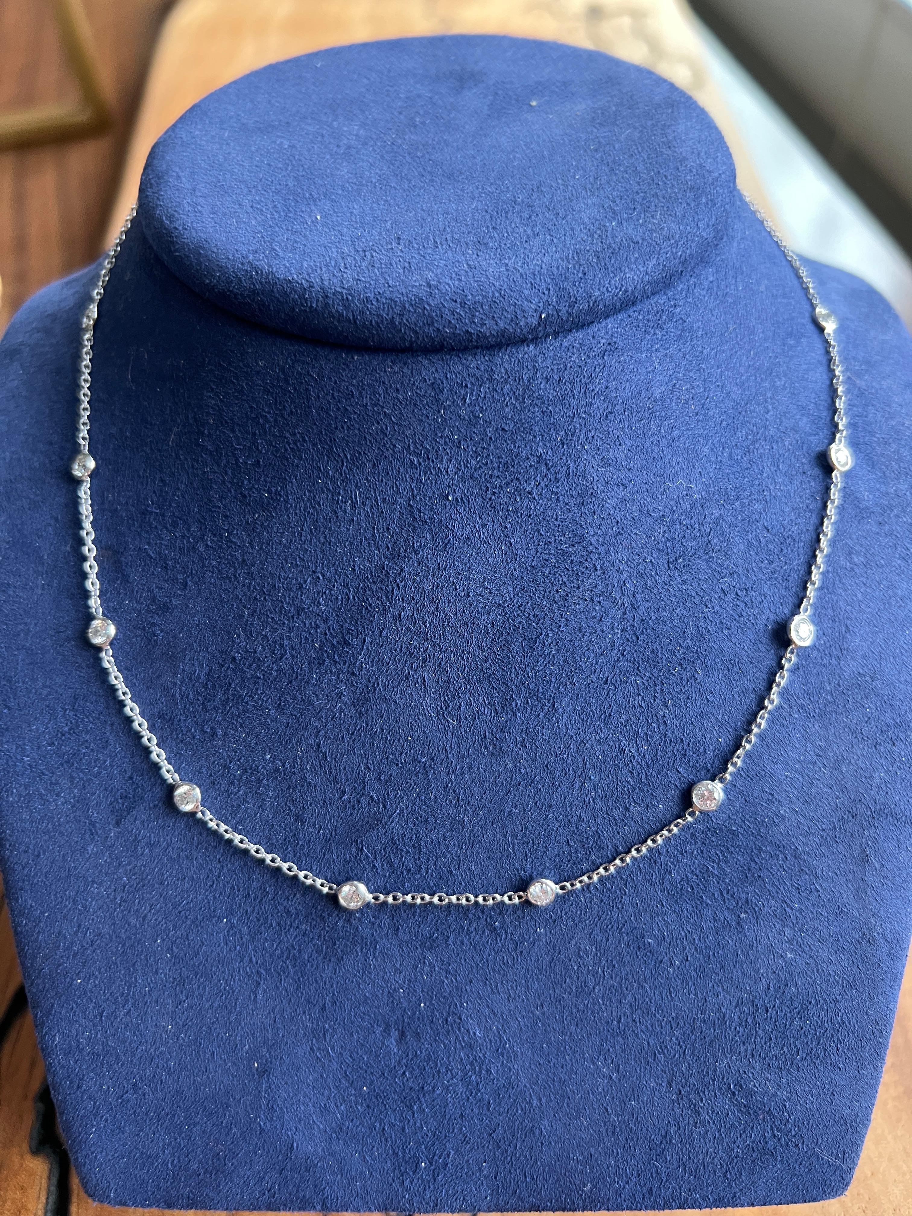 This contemporary 18 karat white gold station necklace features ten bezel-set round brilliant diamonds with a total approximate weight of 1.00 carat. The diamonds are graded G–H in color with SI2 clarity, offering a refined sparkle that adds
