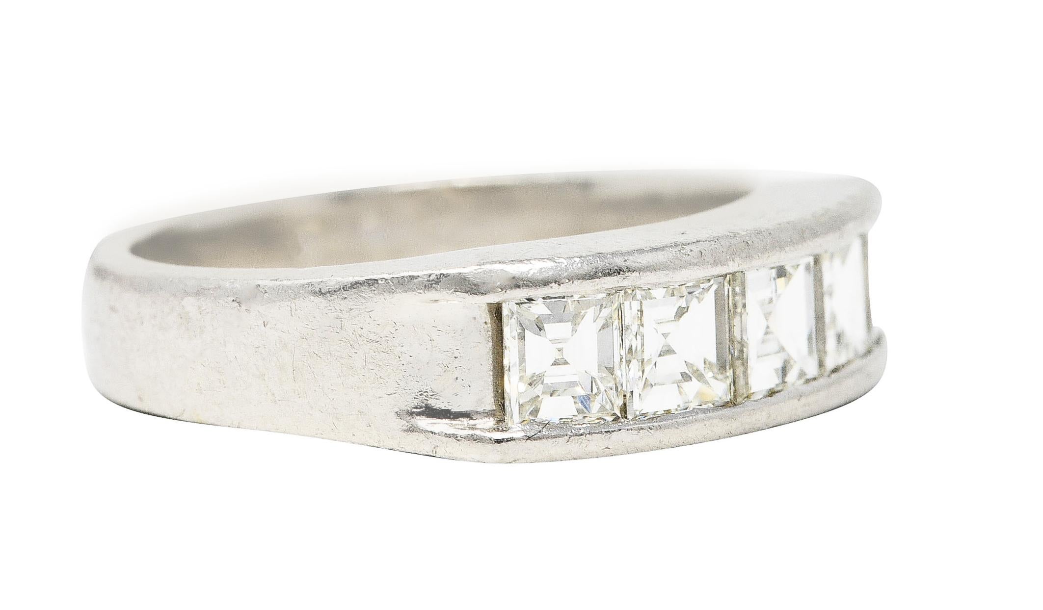Featuring five square step cut diamonds channel set to front. Weighing 1.02 carats total - I to J color with VS clarity. Band accented with grooved shoulders. Stamped for platinum with carat weight inscribed. Circa: 2000's. Ring size: 4 1/2 and