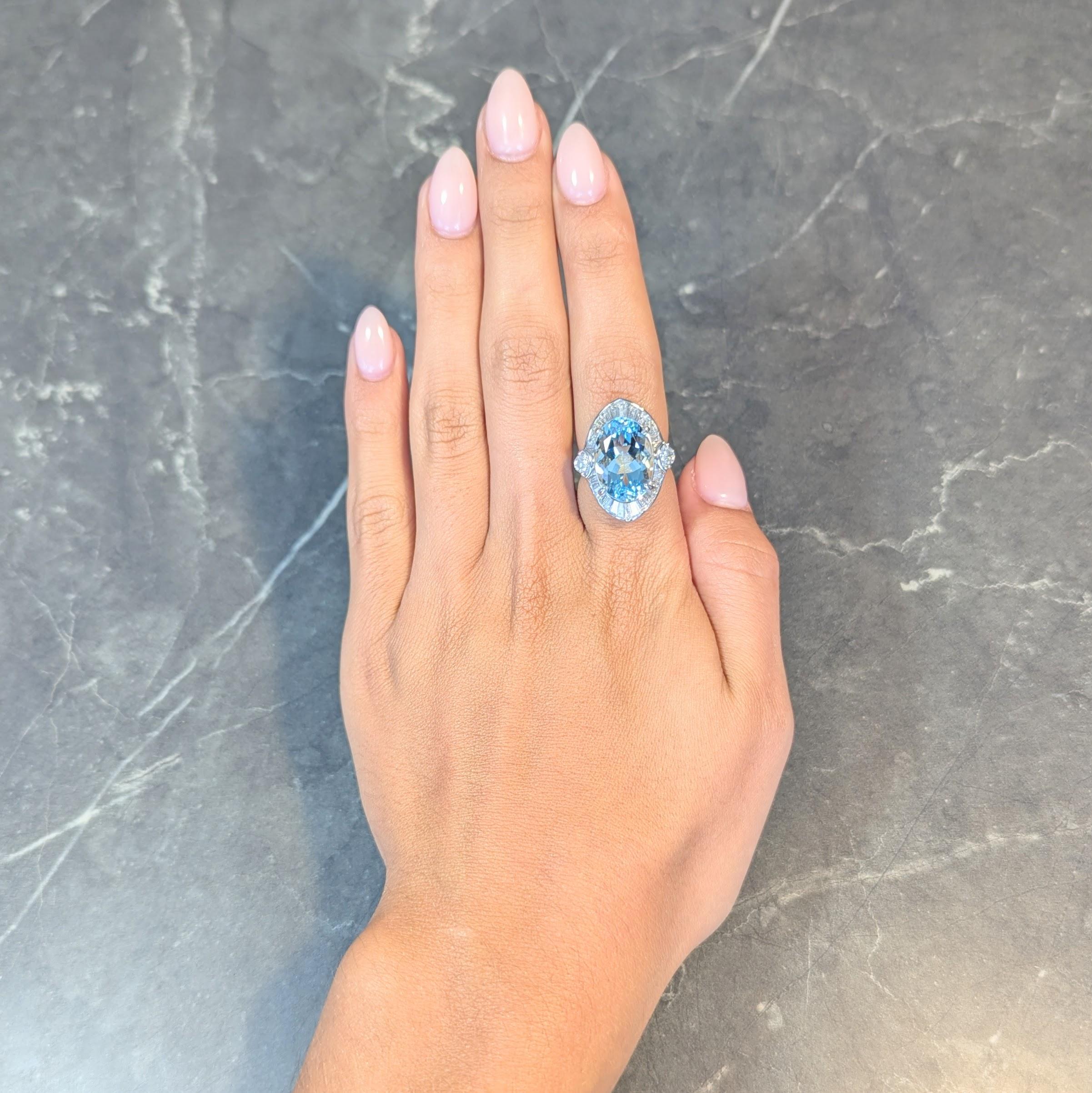 Au centre, une aigue-marine de taille ovale mixte en serti clos pesant 8,93 carats au total. 
Transparent de couleur bleu clair, entouré d'un halo en forme de navette
Style ballerine avec diamants baguettes effilés en serti clos 
Biseauté par des
