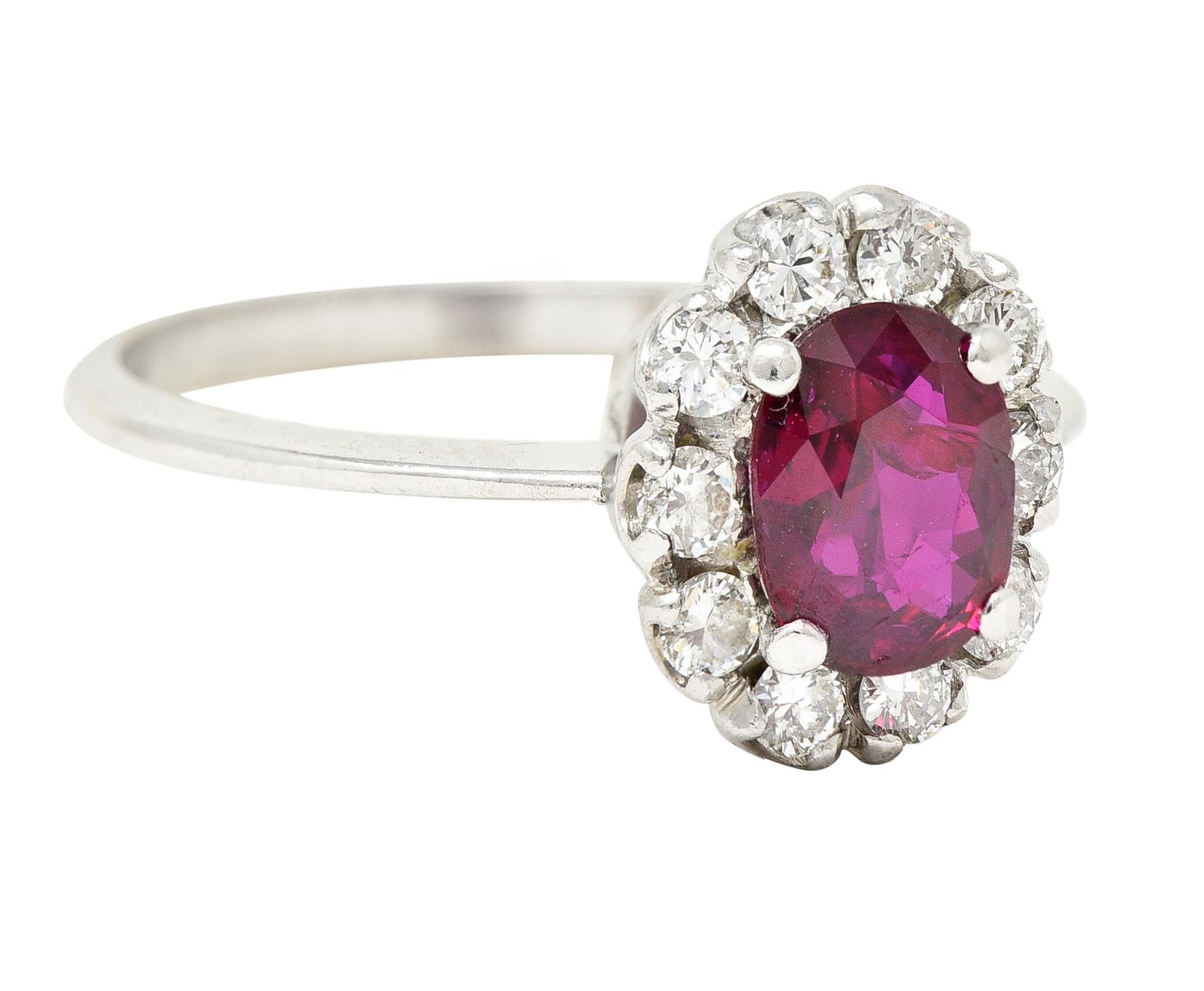 Centering an oval cut ruby weighing approximately 0.78 carat total. Transparent purplish-red in color with medium dark saturation. Prong set with a halo surround of round brilliant cut diamonds. Prong set and weighing approximately 0.30 carat total.
