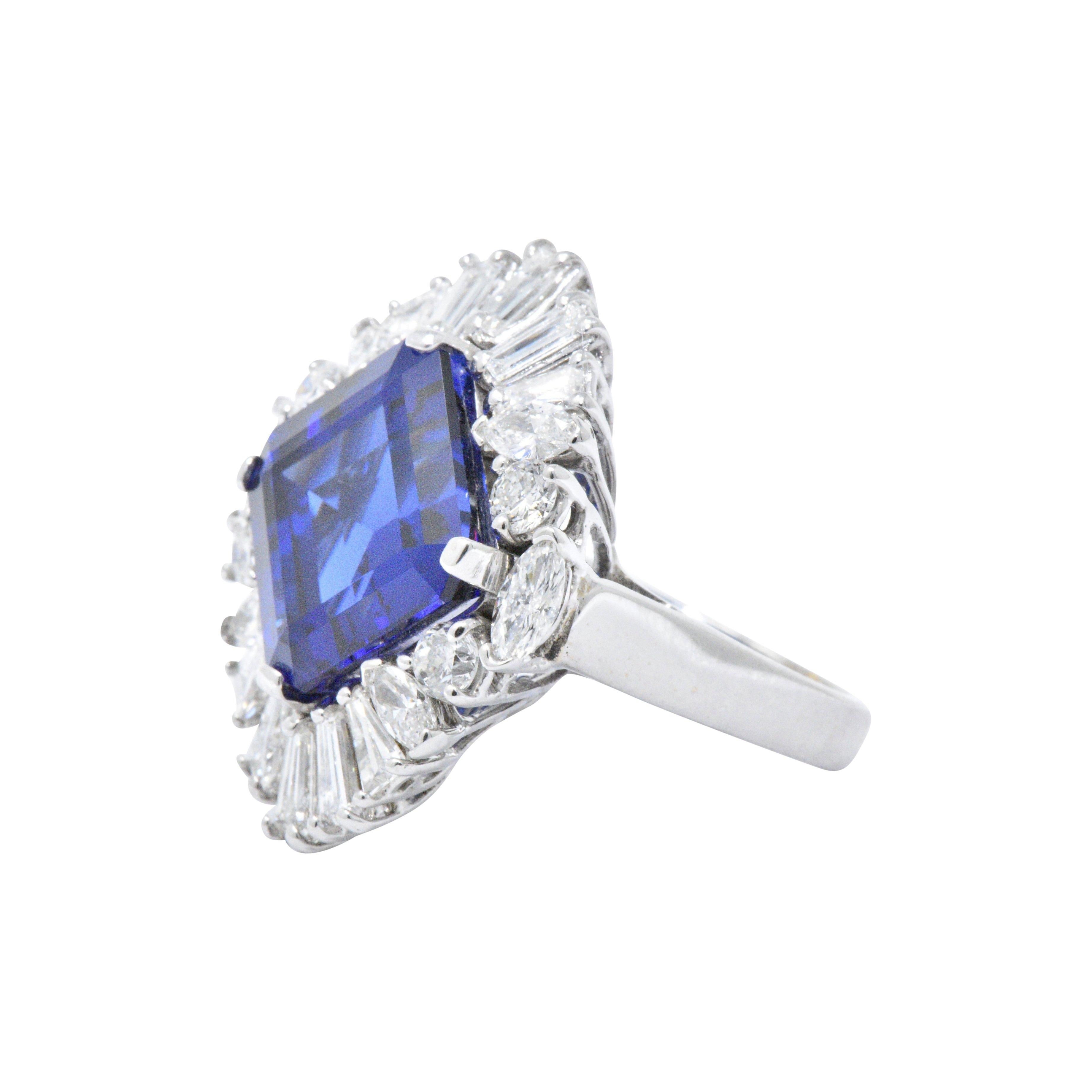 Centering an exceptional 12.00 carat square step cut tanzanite with a rich bright blue color
In a round brilliant, tapered baguette and marquise cut diamond surround, approximately 3.00 carats total, GHI color, VS to SI clarity
This statement ring
