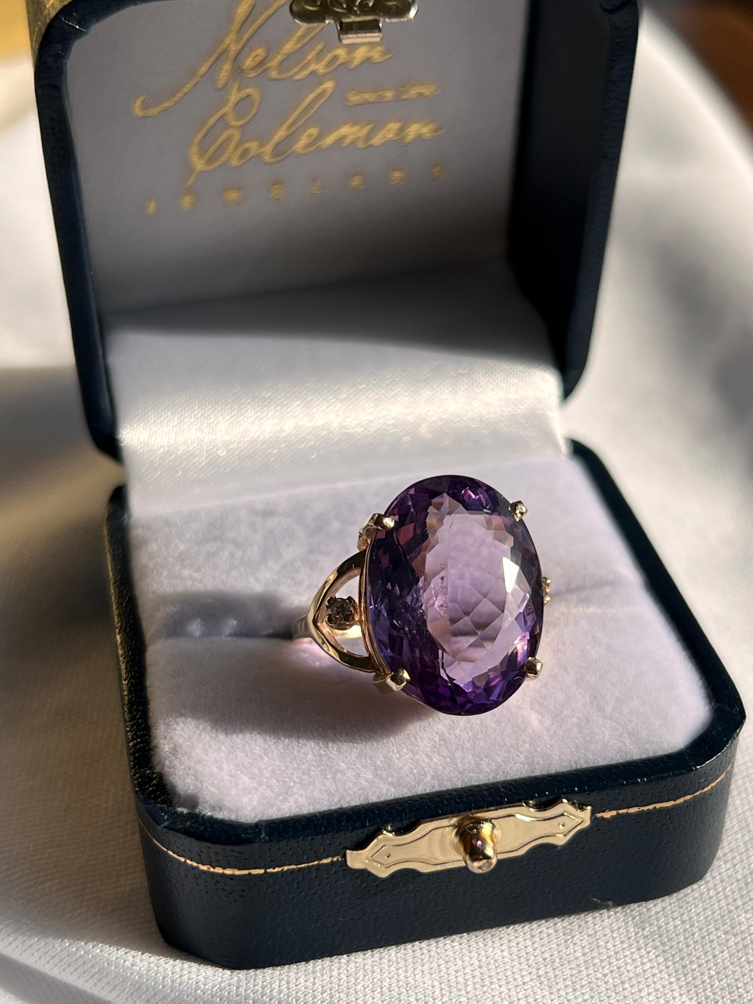 Dieser zeitgenössische Amethystring aus 14-karätigem Gelbgold ist ein kühnes Schmuckstück mit einem beeindruckenden ovalen Amethysten von etwa 12,71 Karat, der von zwei runden Brillanten von insgesamt etwa 0,05 Karat mit der Farbe H und der Reinheit