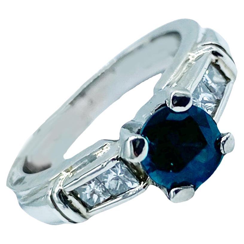 Bague contemporaine en platine, spinelle bleuâtre scintillant et diamant princesse, 1,30 TCW
Les (4) diamants taille princesse mesurent 2,3 mm pour un poids estimé à 0,40 carats.
La monture est une large monture de 4,70 mm en platine et est une